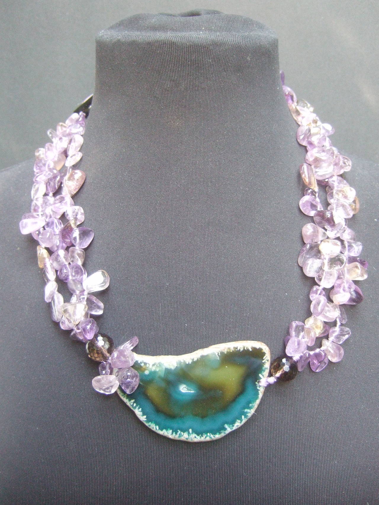 Exotic amethyst sliced agate artisan necklace
The unique handmade necklace is designed with a 
large green sliced agate pendant

The large polished sliced agate is combined with three
strands of translucent polished amethyst rocks 
Each side
