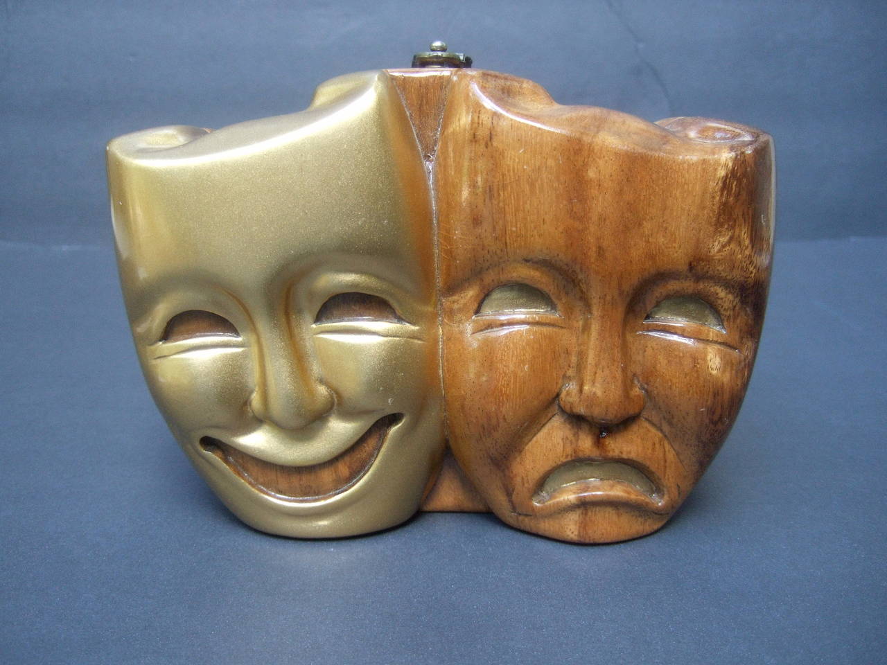 Timmy Woods Beverly Hills Theatrical mask artisan handbag
The unique hand carved artisan handbag is designed from
fallen acacia trees in the Philippines. The carved wood masks 
are designed with comedy and tragedy expressions 
  
The masks are