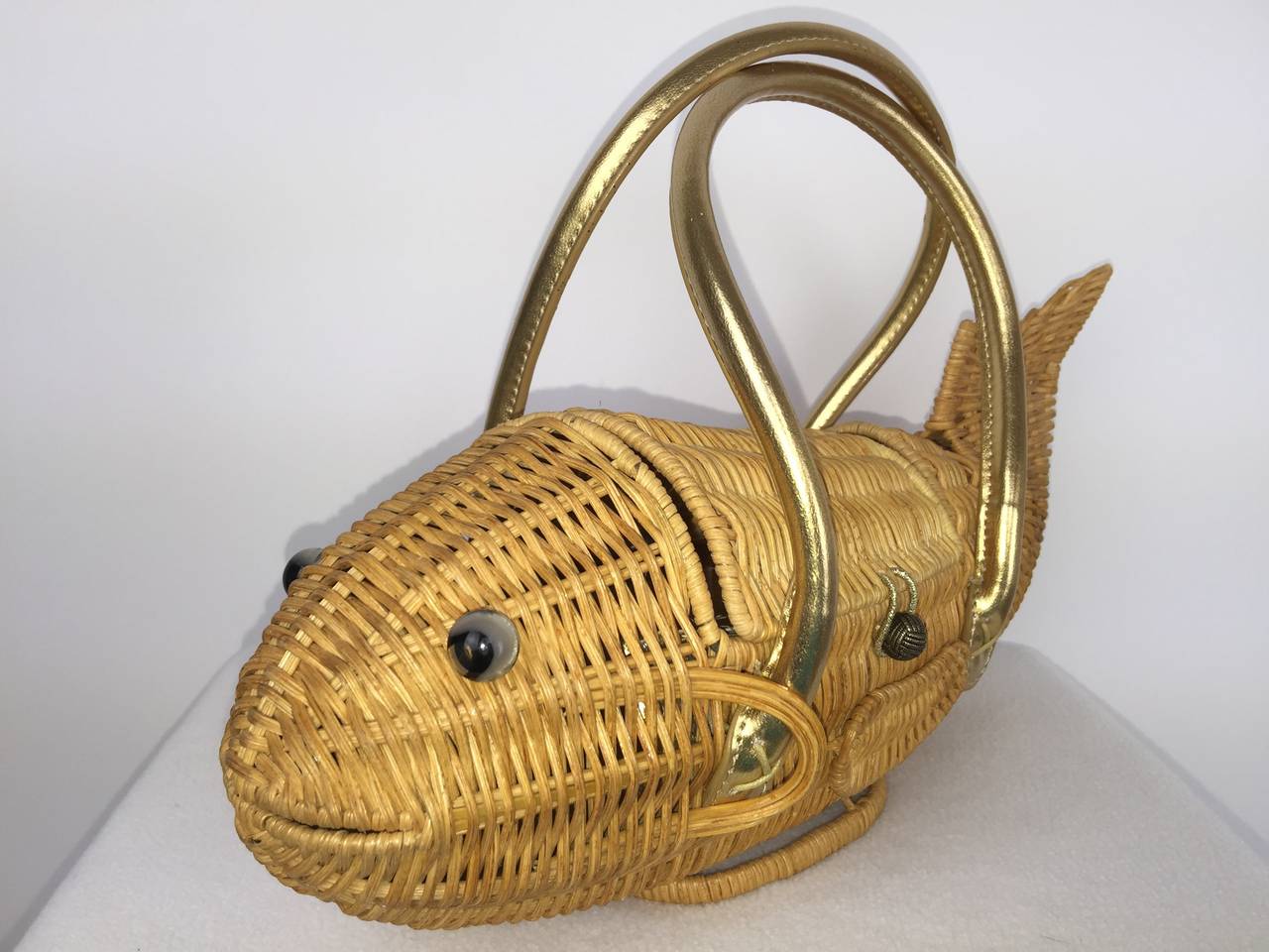Adorable little wicker fish bag.  

Gold faux leather straps.  

Wonderful, shy smile on her face !

Excellent condition inside and out.

Size:

13 inches from tail to nose.
9 inches tall including handle.
5.5 inches tall excluding the