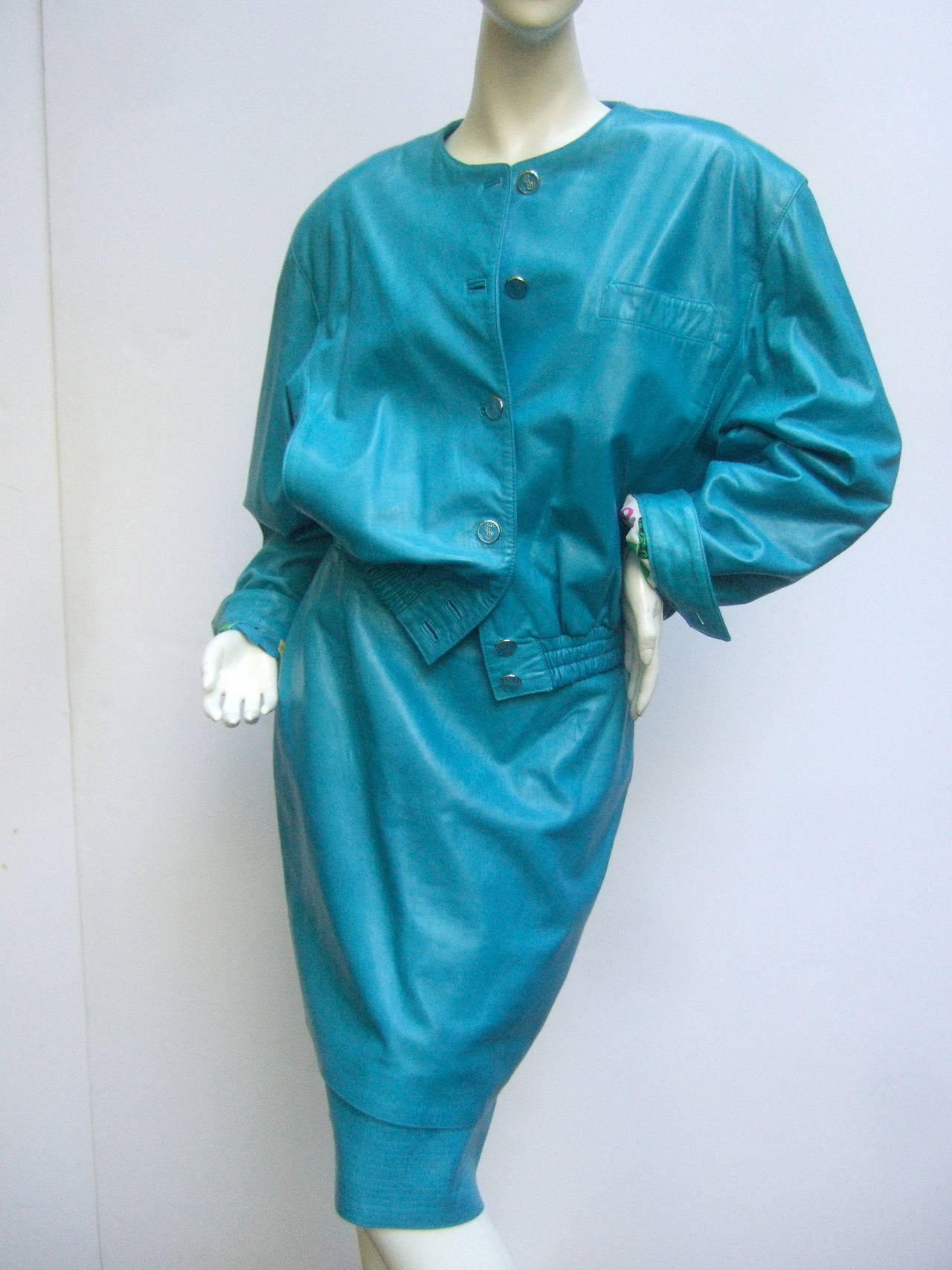 Louis Feraud Turquoise leather Andy Warhol inspired skirt suit Size 40
The bold high fashion designer suit is designed with buttery
soft leather. The interior of the jacket is lined in bold graphics 
with Andy Warhol inspired images; Marilyn