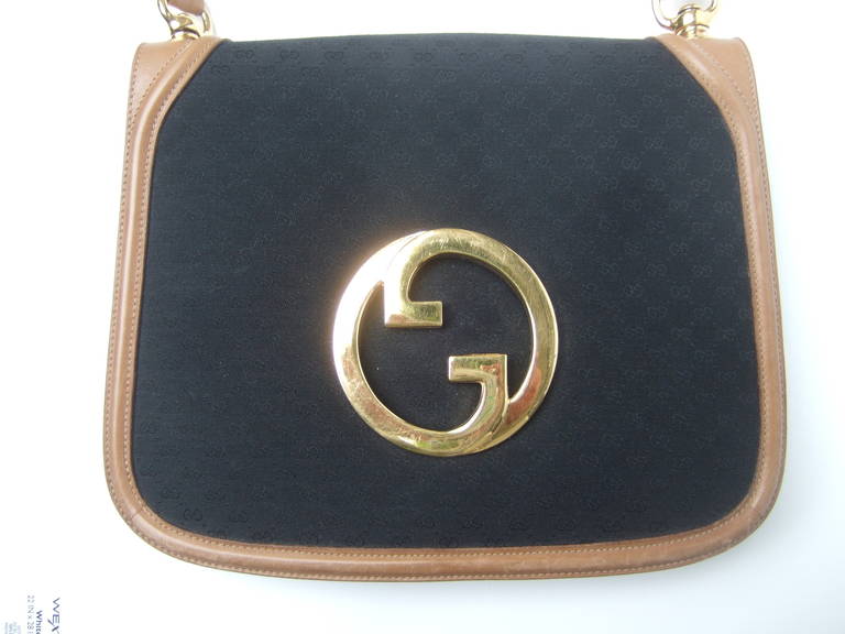 GUCCI Italy Black canvas blondie leather trim shoulder bag ca 1970
The stylish designer handbag is covered in black canvas with 
Gucci's subtle initials repeated throughout. The handbag is 
framed with light brown leather trim & matching shoulder