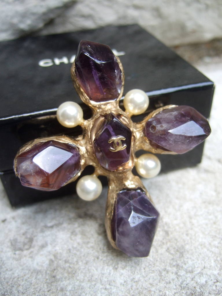 CHANEL Spectacular amethyst & glass pearl cross brooch
The exquisite designer brooch is encrusted with rough cut
faceted amethyst stones designed in a cross symbol

The opulent brooch is embellished with four lustrous glass
pearls. The center