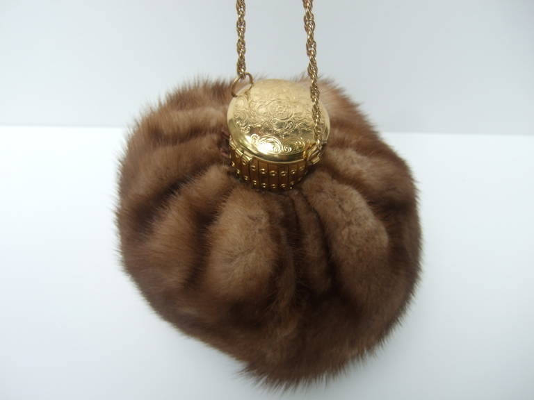 Opulent mink fur round evening bag  c 1960
The luxurious mink fur evening bag is designed in a rounded pouch shape
The elegant purse is adorned with an ornate gilt metal scrolled lid

The mink fur evening bag expands when contents are placed in