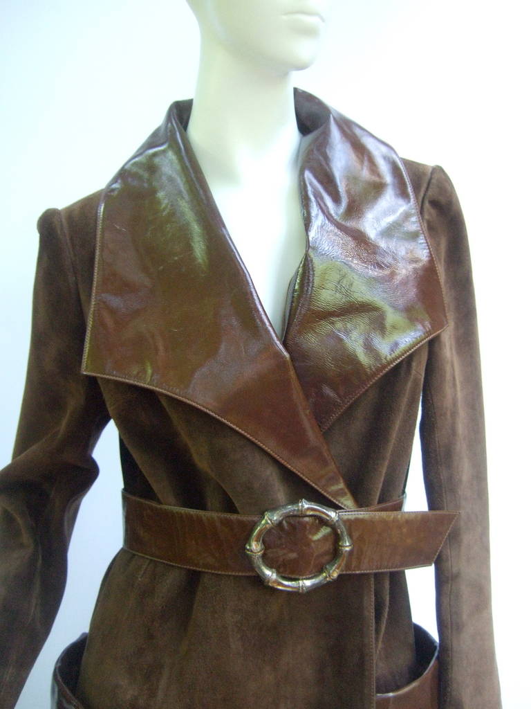 Gucci Brown suede trench coat with sterling silver bamboo buckle ca 1970
The extremely rare coat is designed with plush doeskin suede
The dramatic lapels, belt, pockets & cuffs are designed with 
glossy contrasting brown patent leather

The