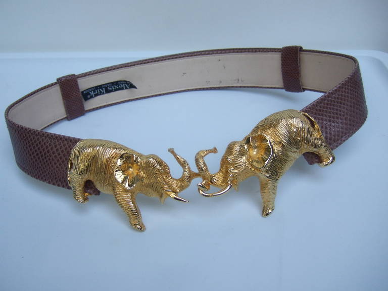 Alexis Kirk Gilt elephant embossed brown leather belt c 1990
The unique belt is designed with a pair of stylized elephants 
for the buckle. The ornate elephant figures are paired with
a brown embossed leather belt that emulates reptile