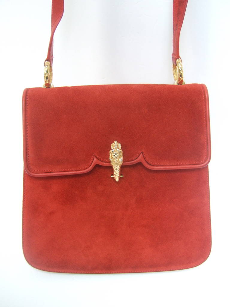 Gucci Italy Scarlet red suede tiger clasp handbag c 1970
The extremely rare Gucci shoulder bag is covered with powdery suede
The clasp is adorned with a gilt metal tiger's head. The leather shoulder strap is anchored with gold metal circular