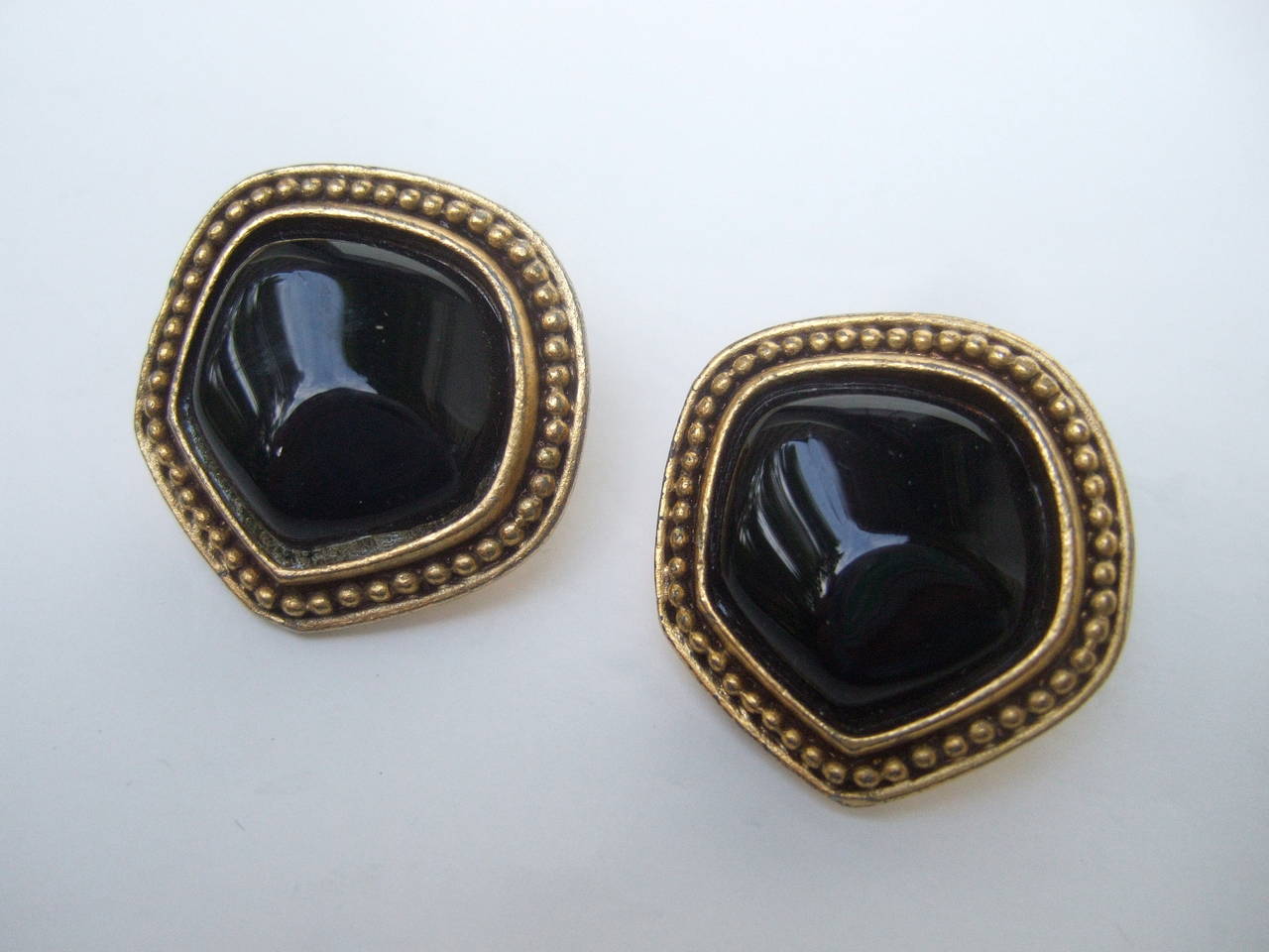 Yves Saint Laurent Poured jet glass button earrings c 1980
The classic button style earrings are designed with glass 
cabochons framed with a gilt metal matte backing

The clip on earrings are stamped: YSL

Measure 1