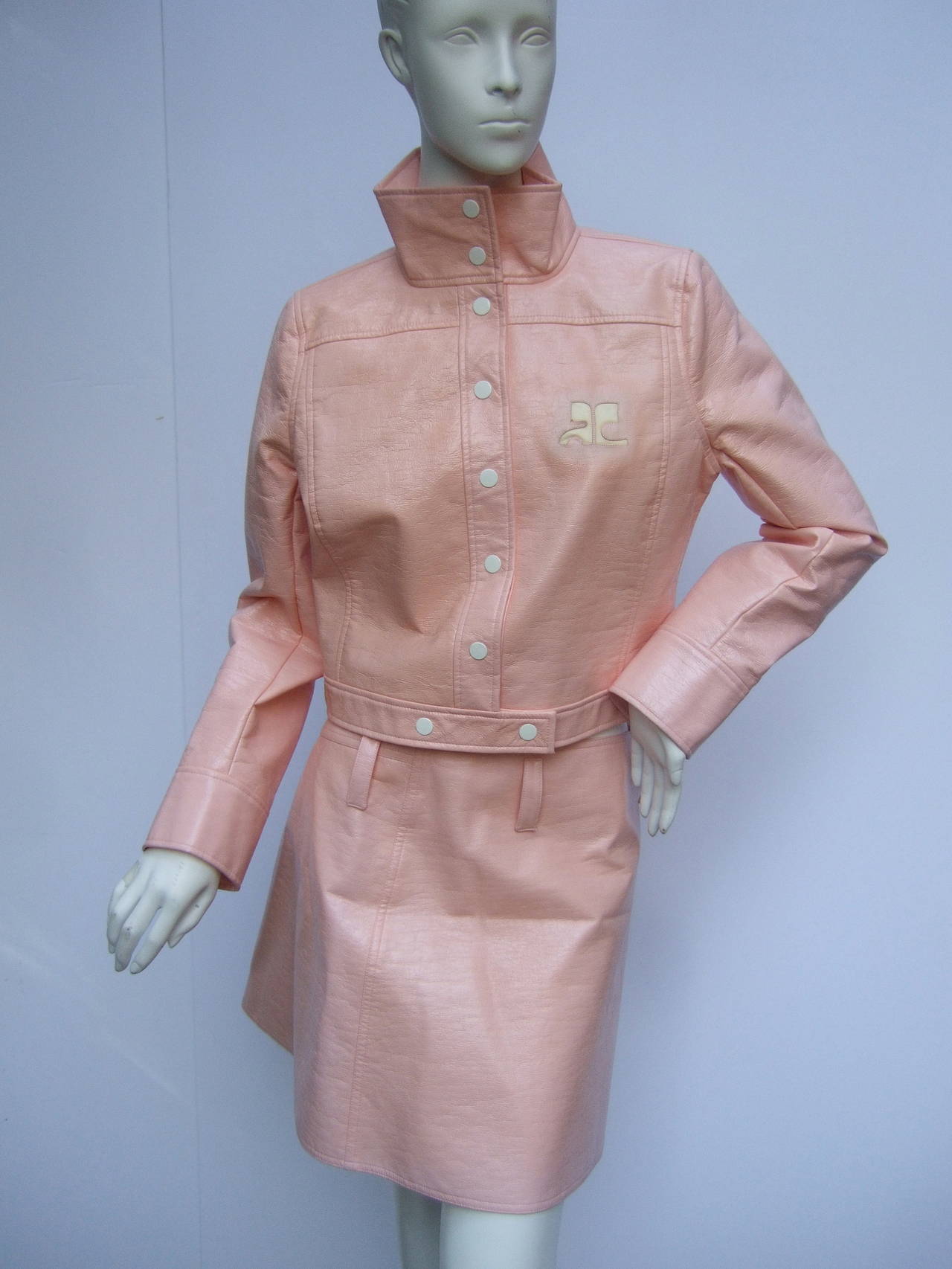 Courreges Paris Iconic cotton candy pink vinyl jacket & skirt Size 40
The crushed vinyl jacket is designed with Courreges's signature initials 
The jacket has a stand up collar & white enamel snap buttons
The jacket waist band overlaps in the
