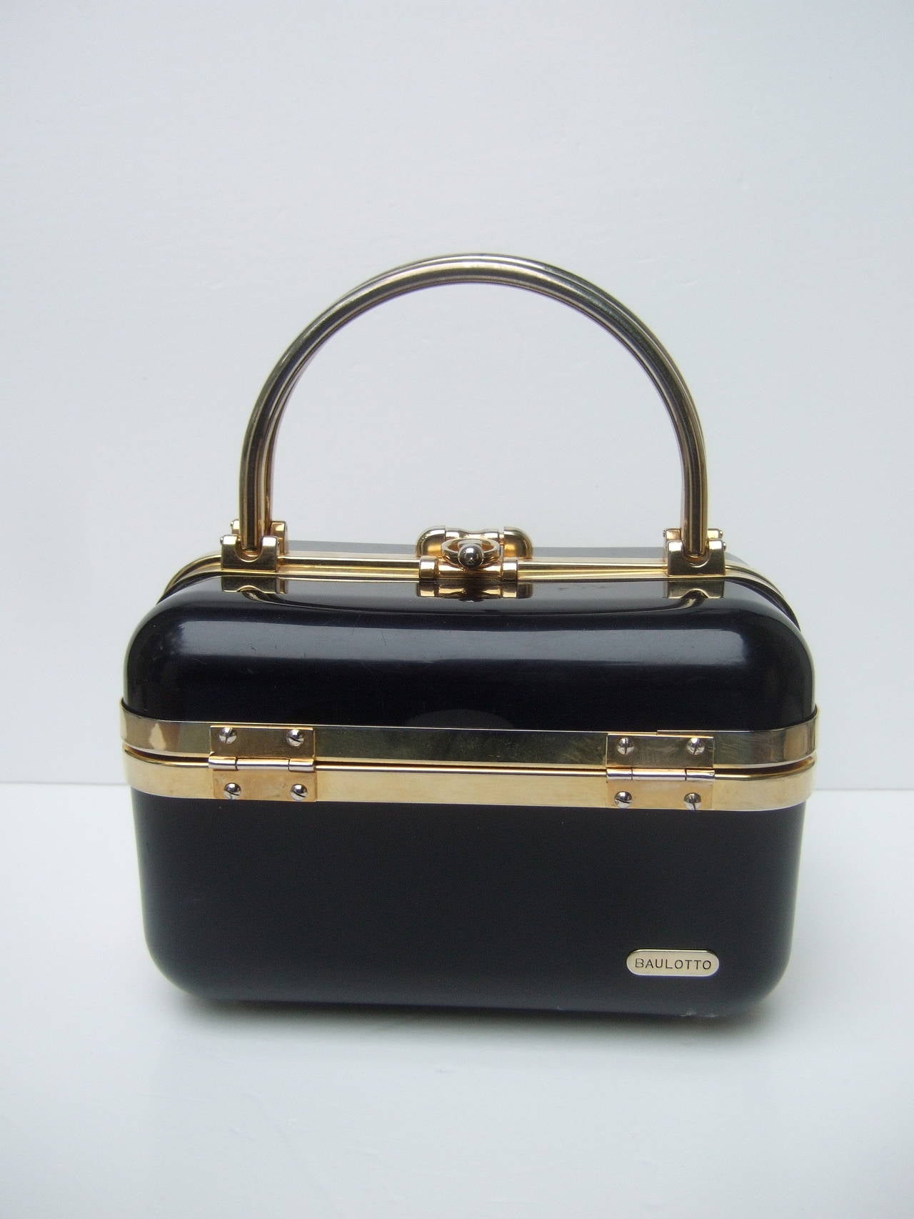 Sleek 1970s Italian ebony lucite handbag designed by Baulotto 
The posh Italian handbag is designed with glossy jet black lucite
The molded panels are accented with gilt metal bands & hardware

The interior of the box style handbag is lined in