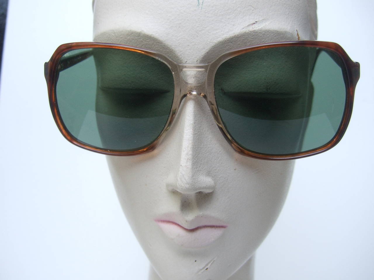YVES SAINT LAURENT Green tinted tortoise shell sunglasses in YSL case 
The stylish mod sunglasses are designed with large tinted green plastic lenses The tortoise shell lucite frames are stamped YSL on both exterior sides with gilt metal plates.