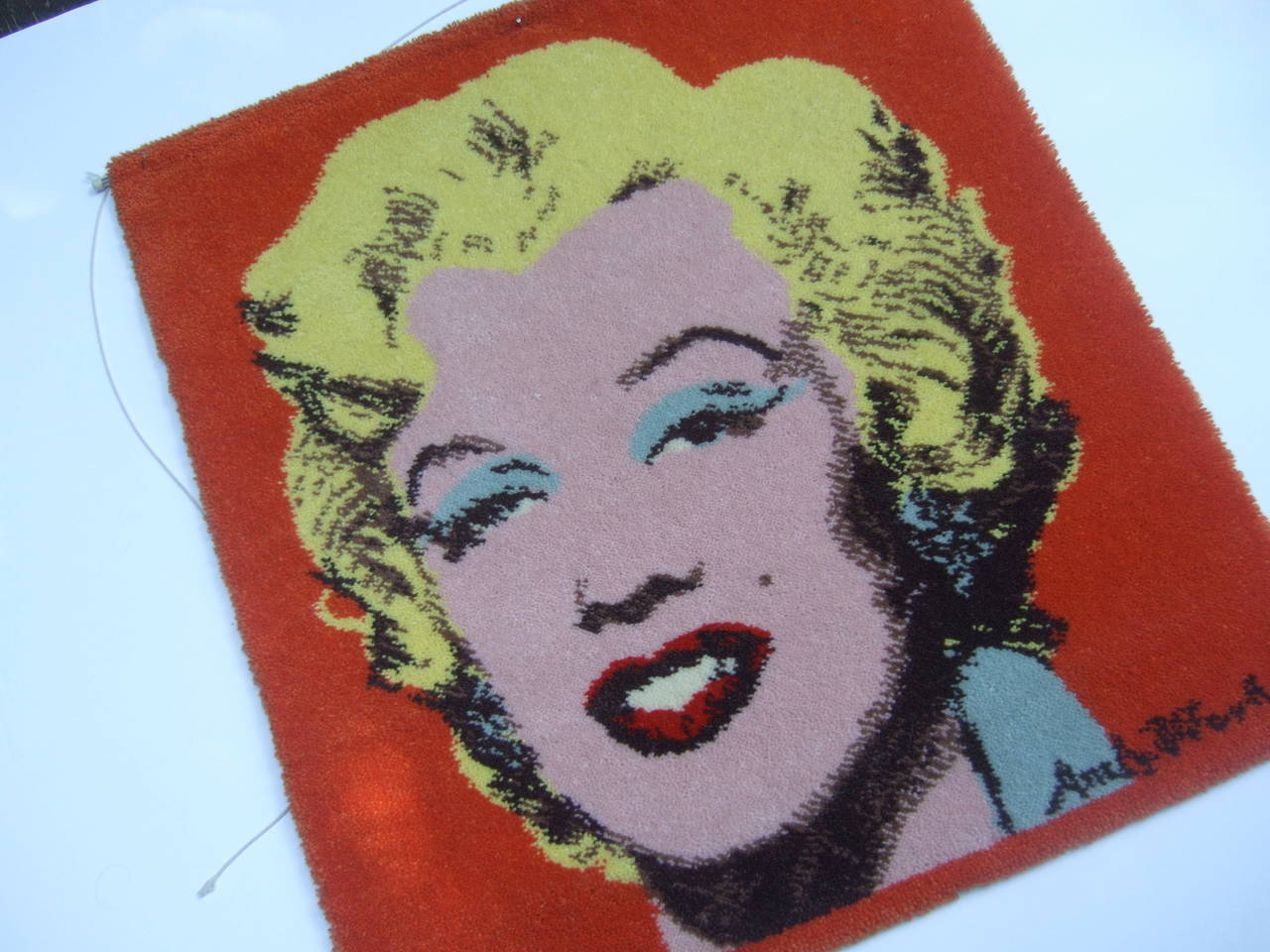 Andy Warhol's Marilyn Monroe replica hook knit wall hanging c 1970s
The iconic image is a replica of Warhol's series of Marilyn Monroe
silk screen images

The machine made hook knit rug is designed with Marilyn Monroe's
iconic image. The wall