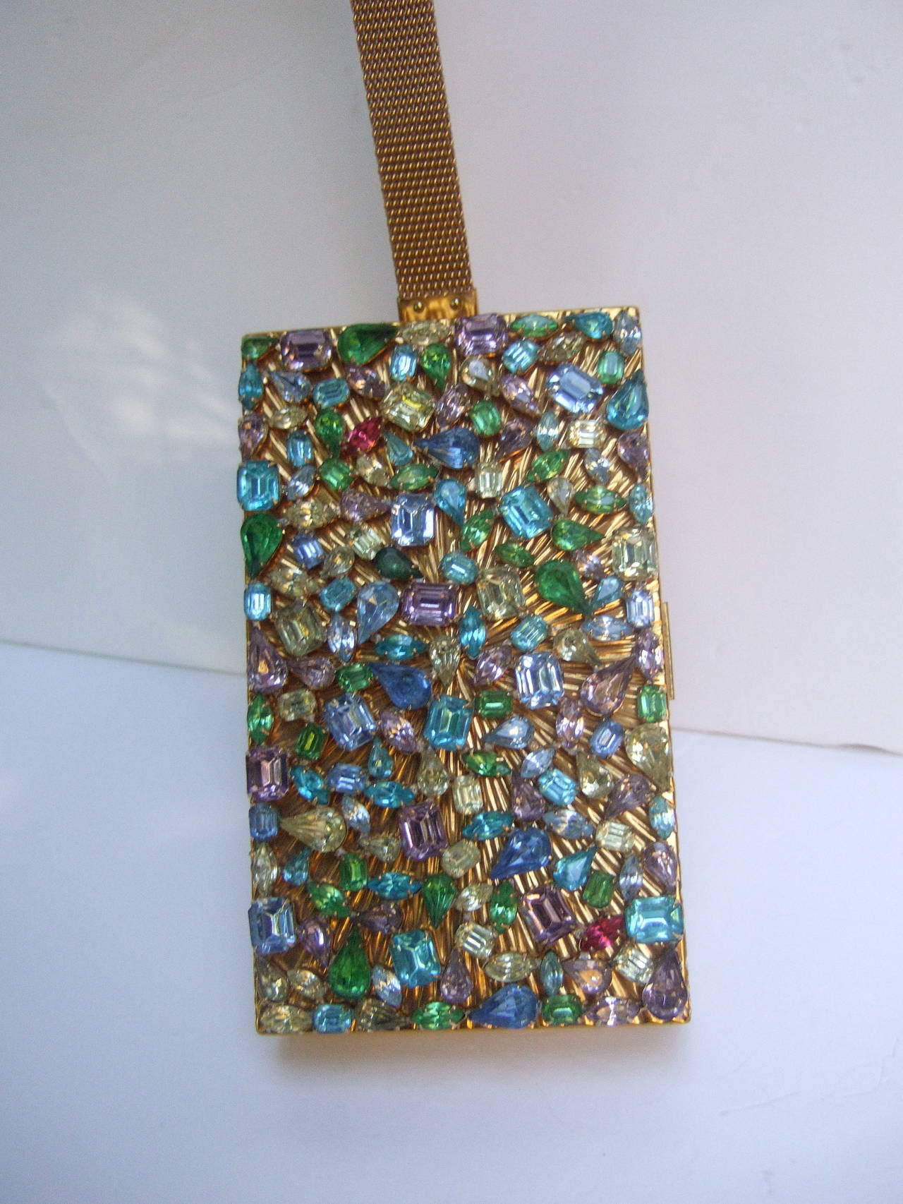 EVANS Crystal encrusted evening bag cigarette case compact c 1960
The opulent evening bag / cigarette case / compact is embellished with a collection of brilliant glittering pastels crystals. The prong set crystals cover the front exterior panel of