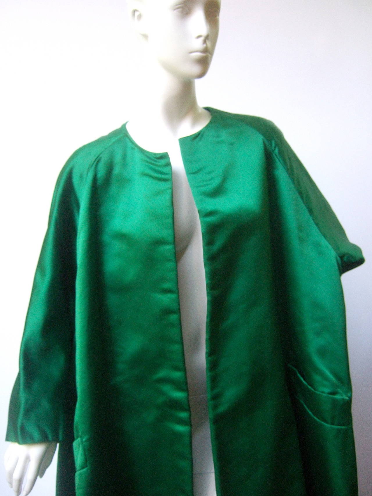Neiman Marcus Emerald green duchess satin evening coat c 1960
The couture style coat is designed with sumptuous silk satin fabric
The chic evening coat is designed without any buttons or closures 

The voluminous coat has a slight flared