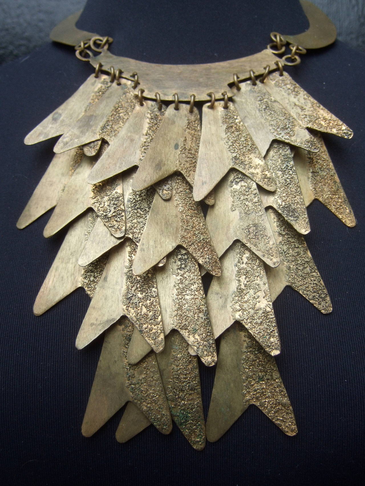 Spectacular Italian articulated gilt metal bib necklace designed by Silvana
The handmade artisan necklace is designed with hinged gilt metal tiles 
The hinged tiles have a brushed gilt matte metal finish. The tiles are partially
designed with a