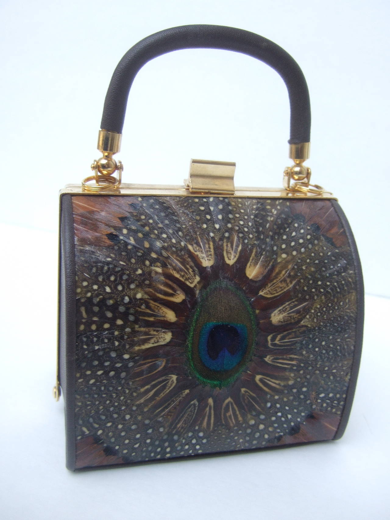 Exotic peacock feather diminutive handbag c 1980
The compact unique handbag is covered with peacock feathers on both exterior sides. The versatile handbag may also be worn as a shoulder bag with the detachable shoulder strap

The posh handbag is