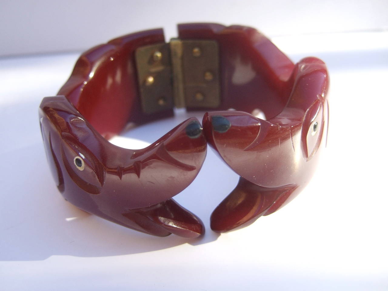 Spectacular Art Deco carved bakelite hounds clamper bracelet c 1930s
The amazing bakelite hinged bracelet is designed with a pair of hounds facing each other. The extraordinary carved bracelet is designed with a cinnabar color bakelite with enamel