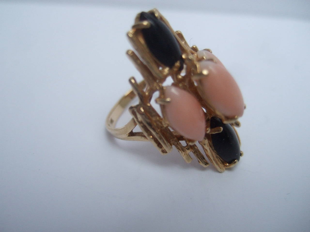 Angel skin coral & jet stone 14k gold ring Size 7.25
The elegant ring is designed with three oval shaped angel skin coral settings juxaposed with two oval shaped jet stones on both center edges

The prong set stones are set in 14k gold metal