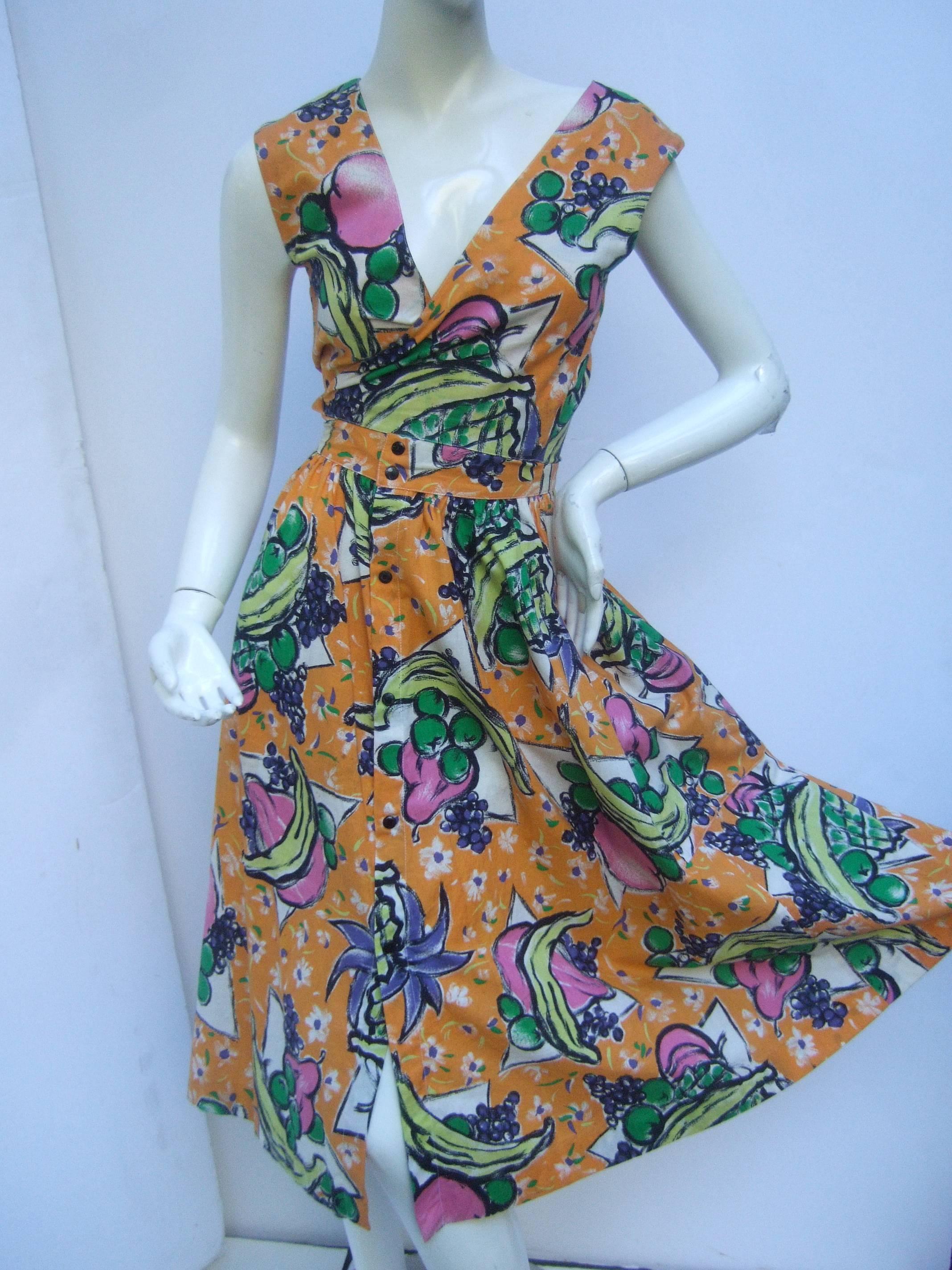 Vintage French peasant dress by Prestige de Chafflet 
The cotton print dress is illustrated with a collage 
of vibrant fruits set against a golden yellow back-
ground 

The French print dress is designed with unique
snap closures on the bodice