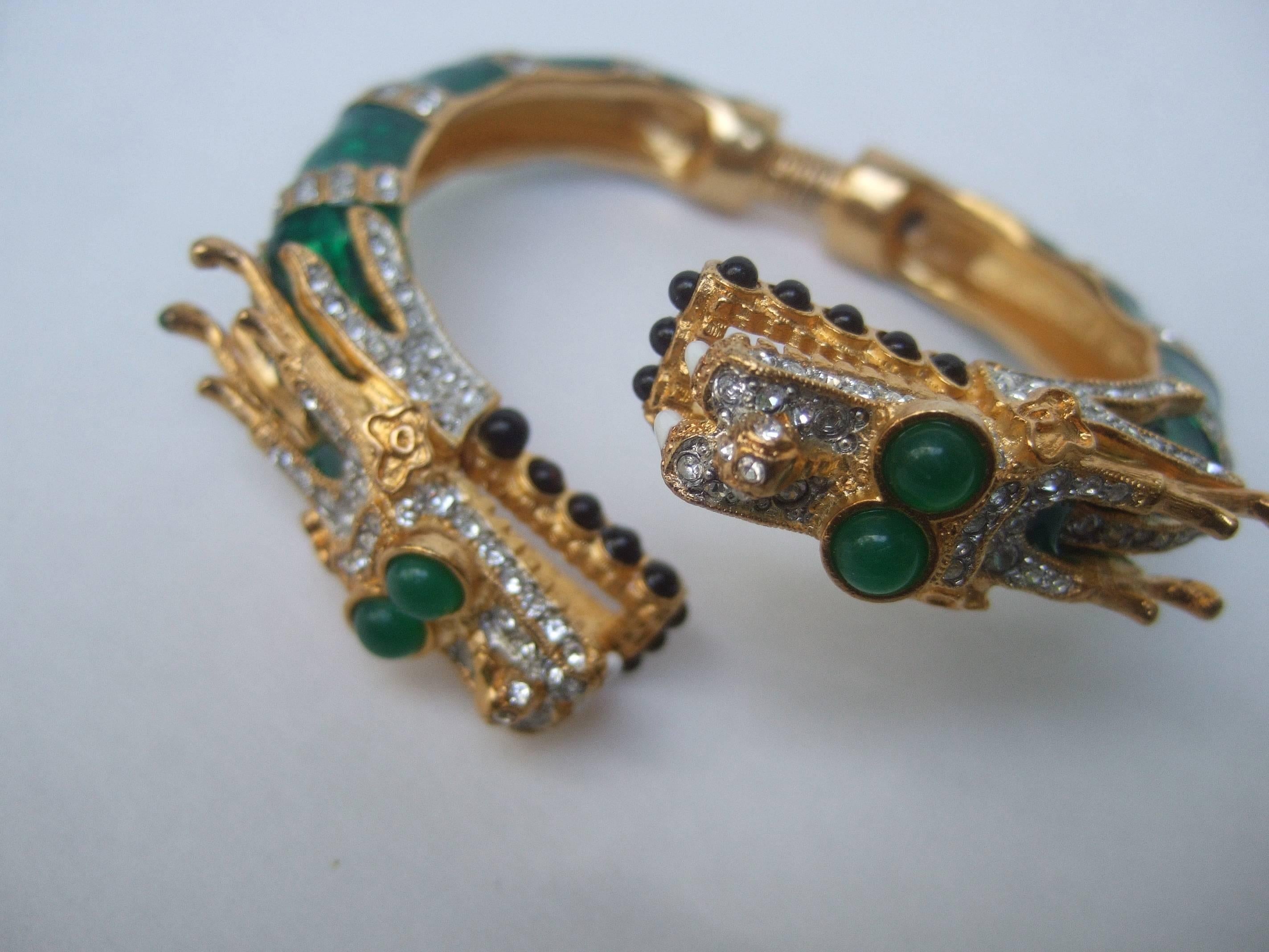 
Ken Lane exotic jeweled enamel dragon bracelet.

This avant-garde designer costume bracelet is designed with a pair of gilt metal jeweled dragon heads.

The dragons are embellished with green resin cabochon eyes accented with diamante crystals