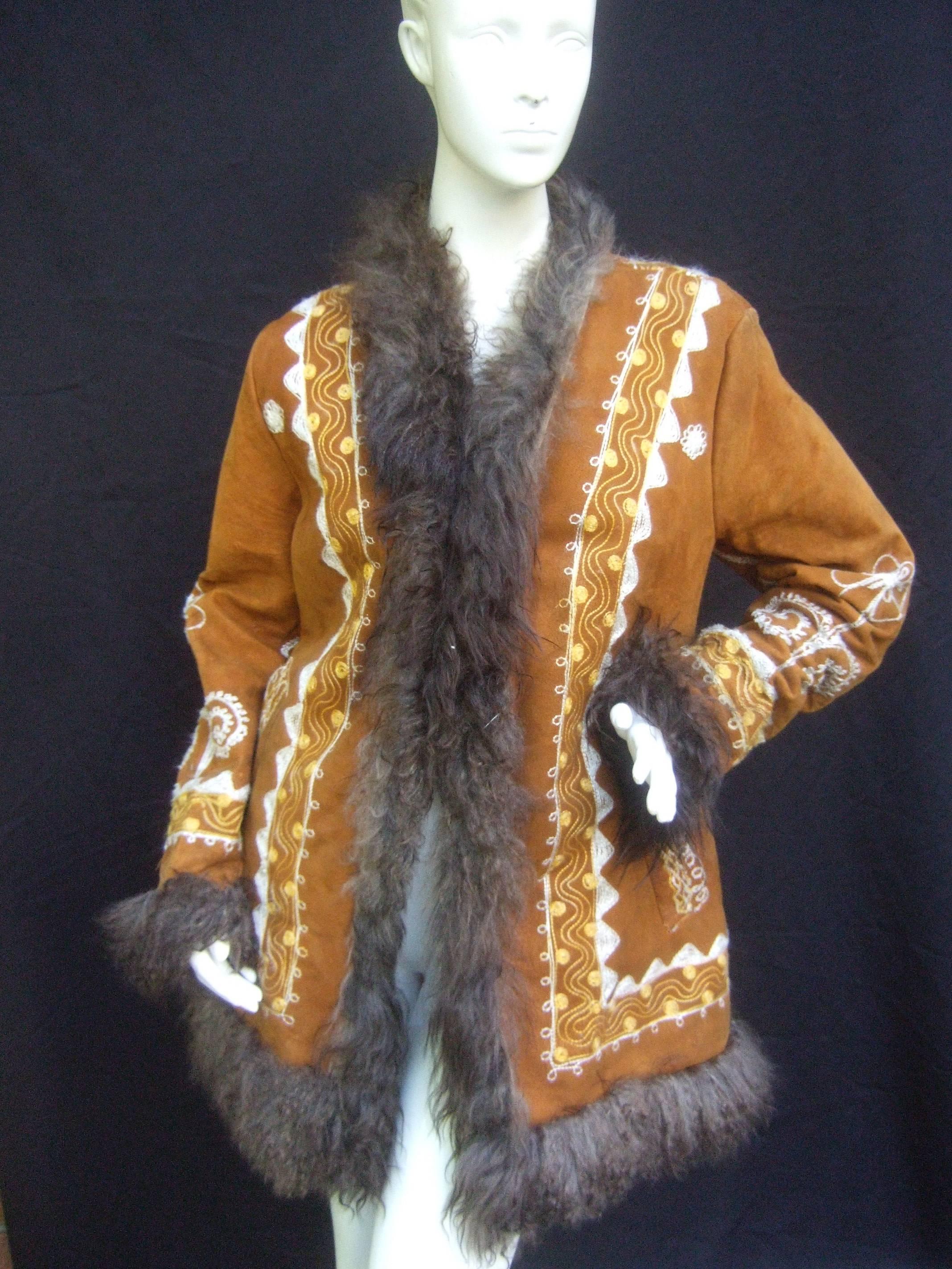 Genuine Afghan suede embroidered coat 
The boho style coat is designed fluffy
brown curly fur that runs down the front 
and circles the hemline

The caramel brown suede exterior 
is designed with elaborate embroidery
that extends to the