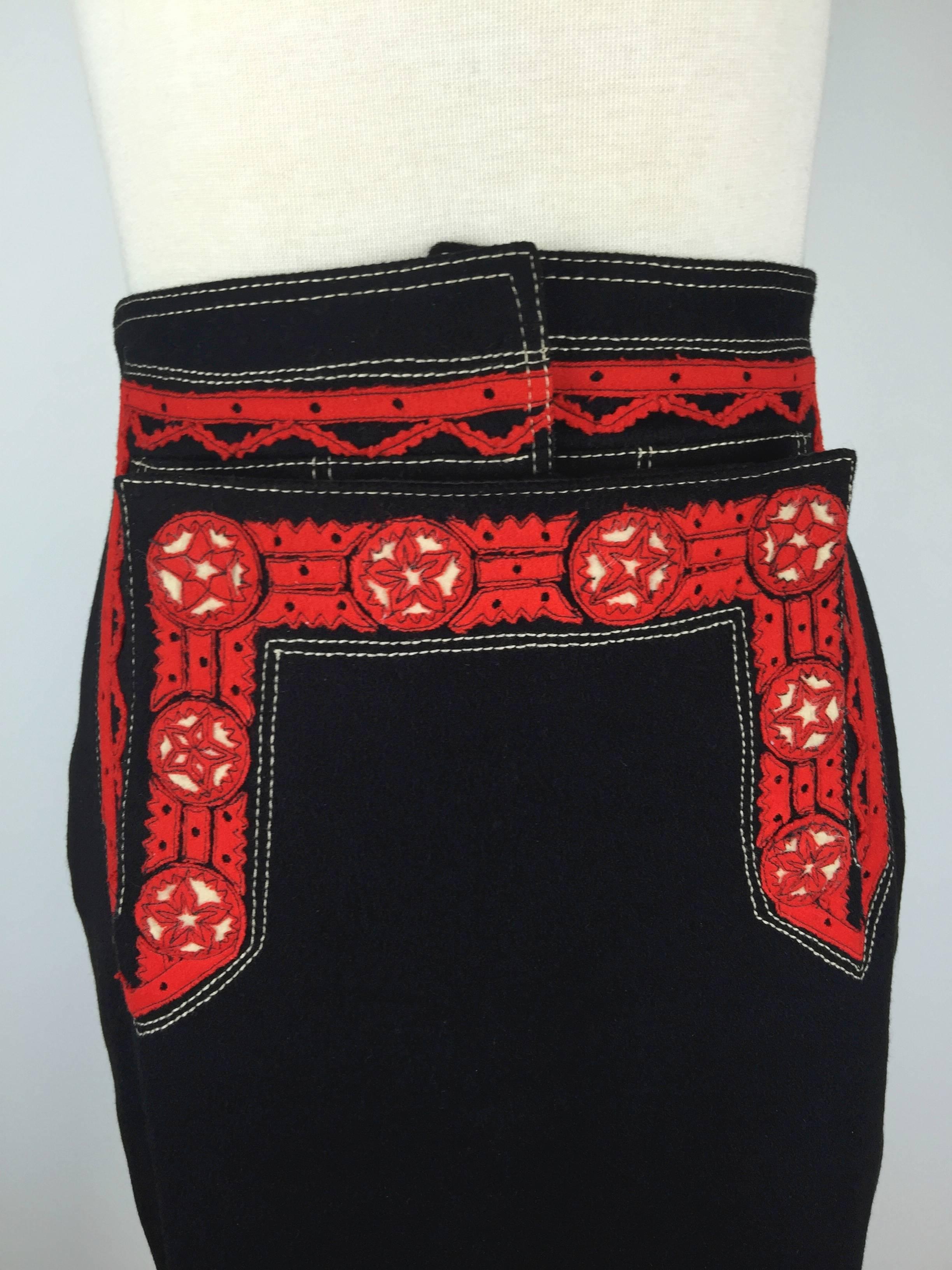 
Fabulous black felted wool skirt with red and white folkloric decoration
and lederhosen style fastenings with lots of horn buttons.

It laces at the back with a nod to Gaultier's iconic corset designs.

The smooth black felted wool is