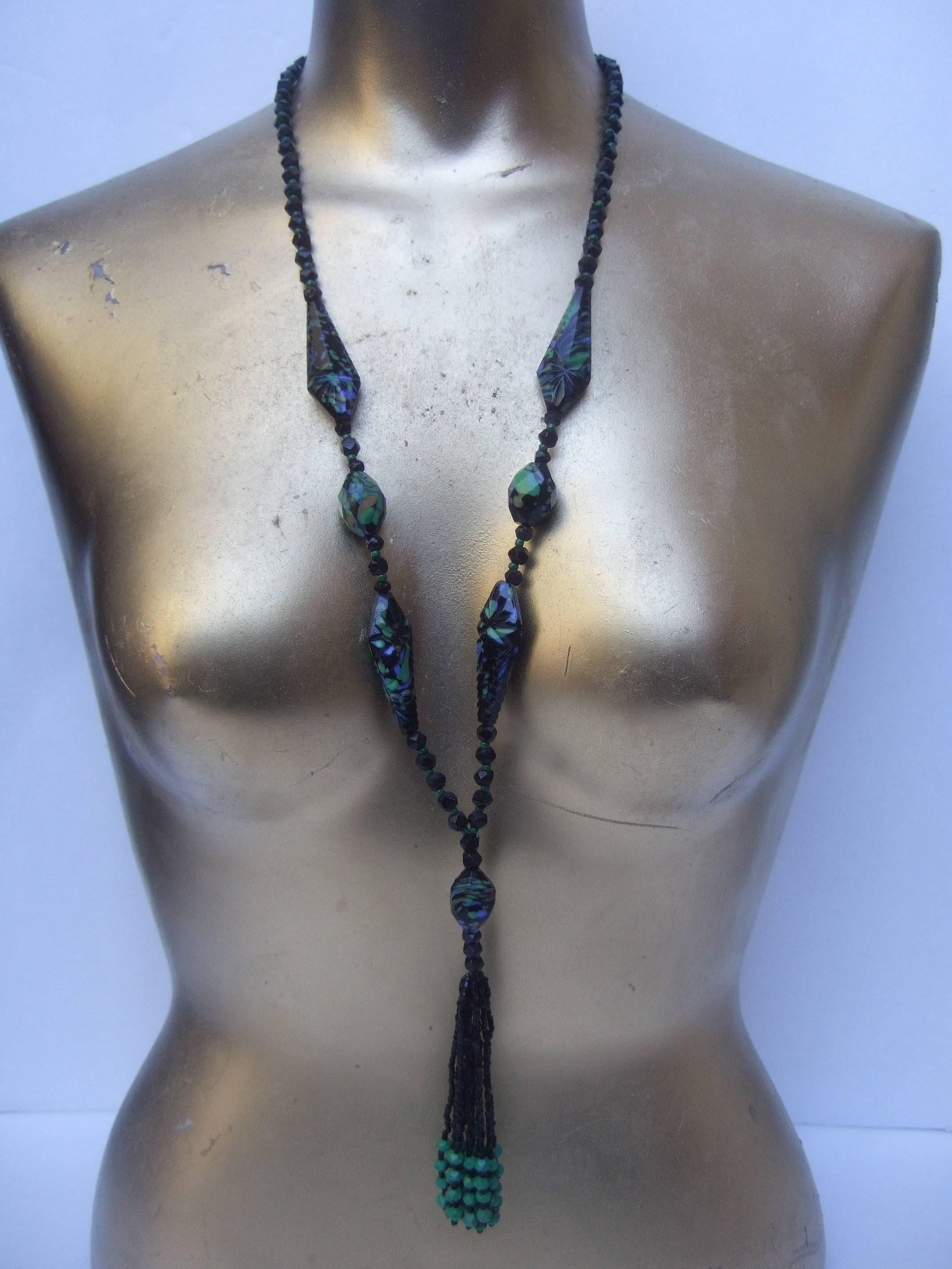 Art Deco Glass beaded sautoir necklace c 1930s
The elegant tassel necklace is designed 
with jet glass beads in various sizes and
shapes; juxtaposed with muted pale green
beads

Some of the larger elongated glass beads
are faceted black glass