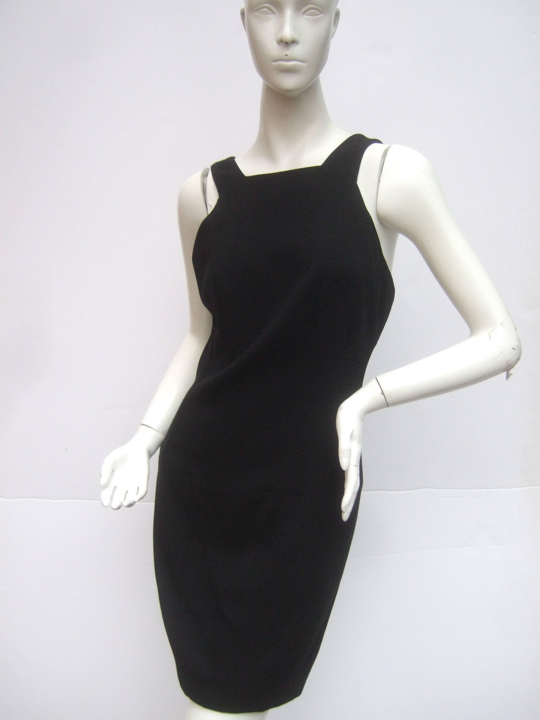 Chanel Boutique Chic black wool cocktail dress Size 42
The stylish high fashion dress is designed with shoulder
straps embellished with four black resin Chanel buttons

The Chanel buttons secure the shoulder straps
and are placed on the back