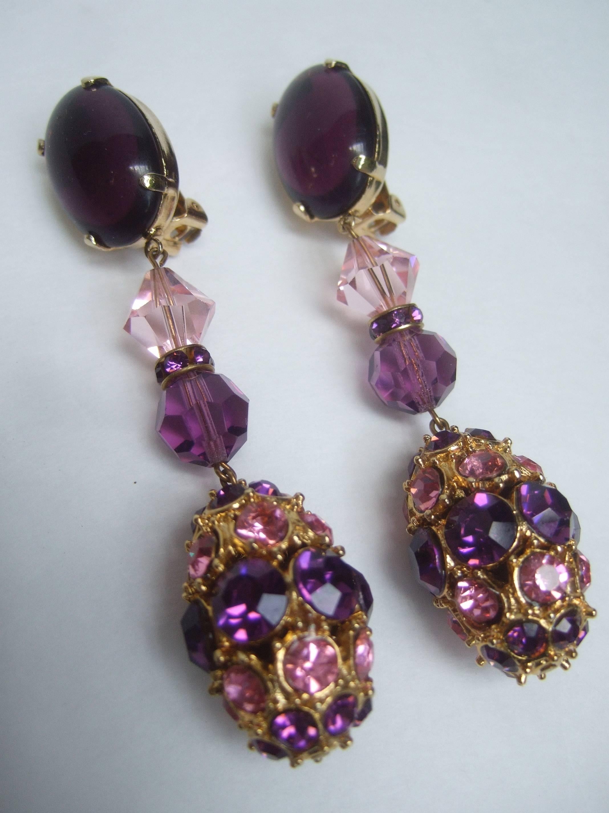 Massive glittering amethyst crystal dangling earrings c 1970
The crystal encrusted earrings are embellished 
with brilliant purple and pink crystals in various
shapes and sizes

The top of the clip on earrings are adorned 
with a large oval