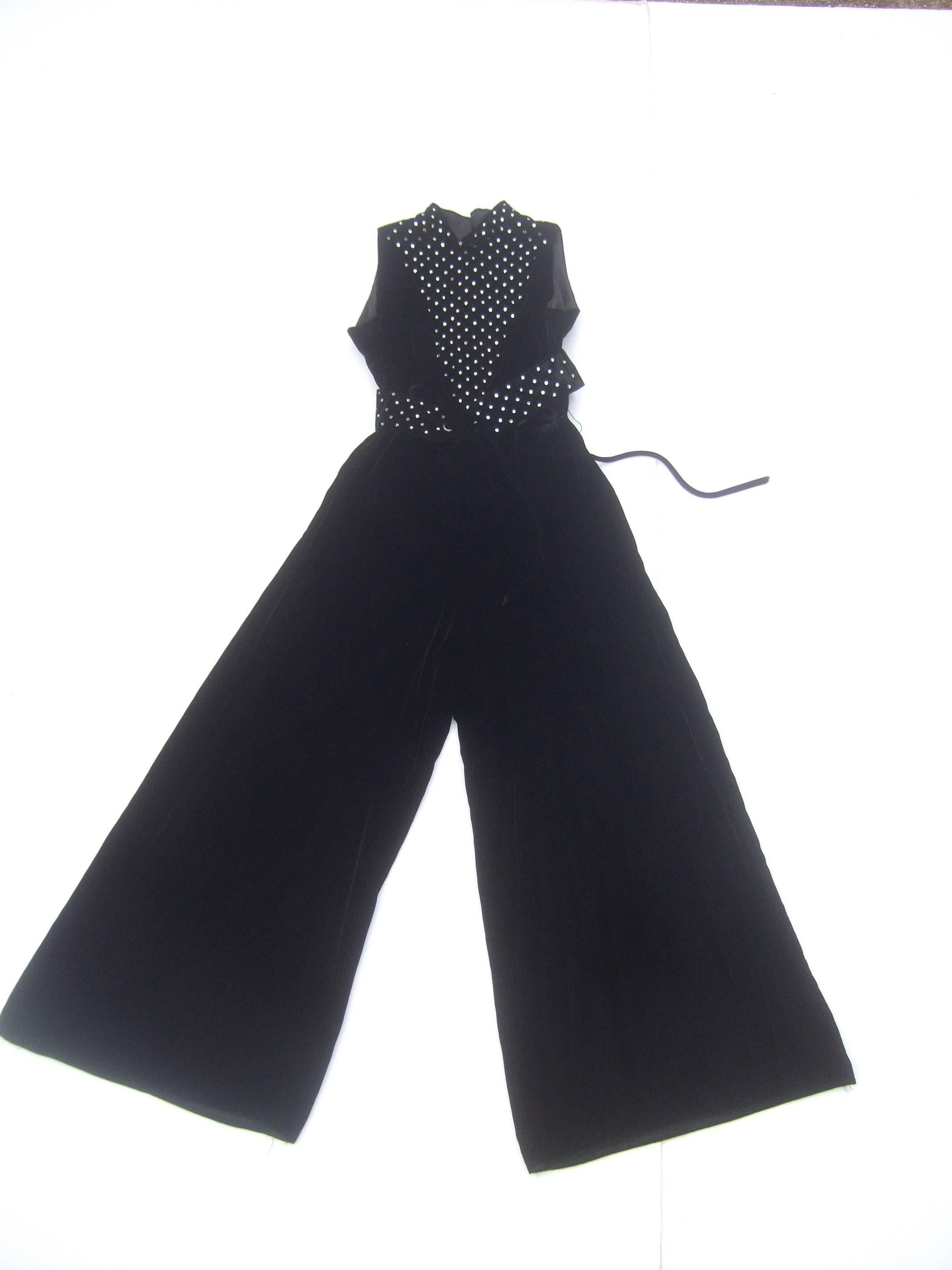1970s Spectacular black silk velvet crystal bodice jumpsuit 
The chic black velvet jumpsuit is embellished with glittering
prone set diamante crystals on the sleeveless bodice 
in a v shaped design 

The waist is delineated with a matching wide