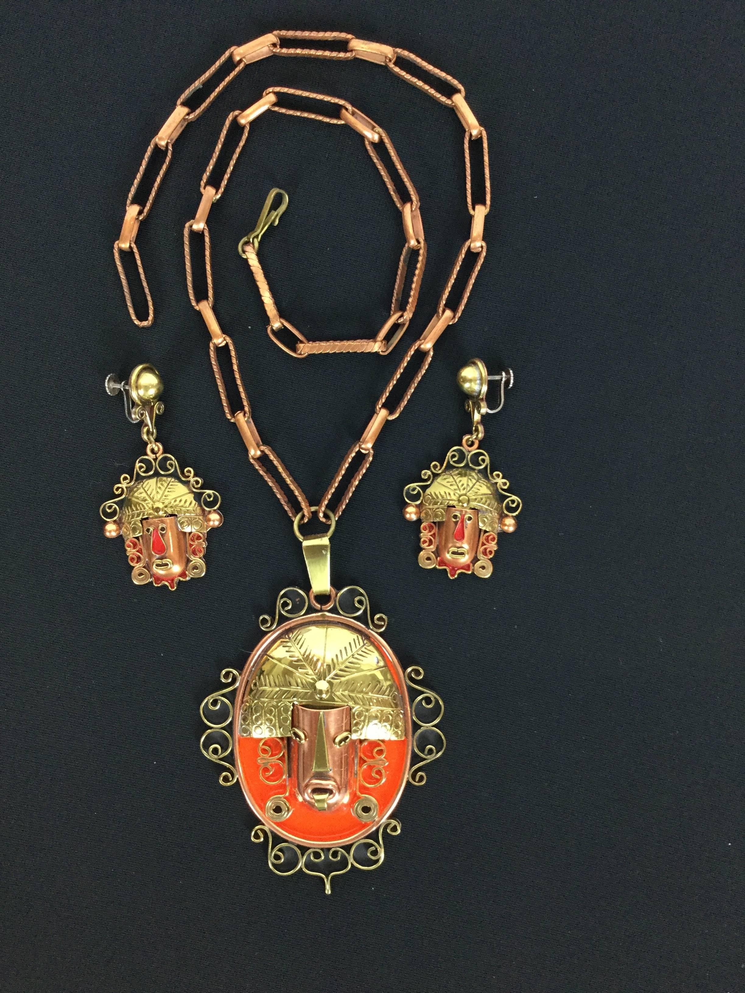 
This set is so striking and usual.  

It takes the theme of highly stylized faces rendered in brass, copper, and enamel.

The enamel is a sort of orangey/red.

Very Tribal and dramatic.  Definitely a set for those who like their
costume