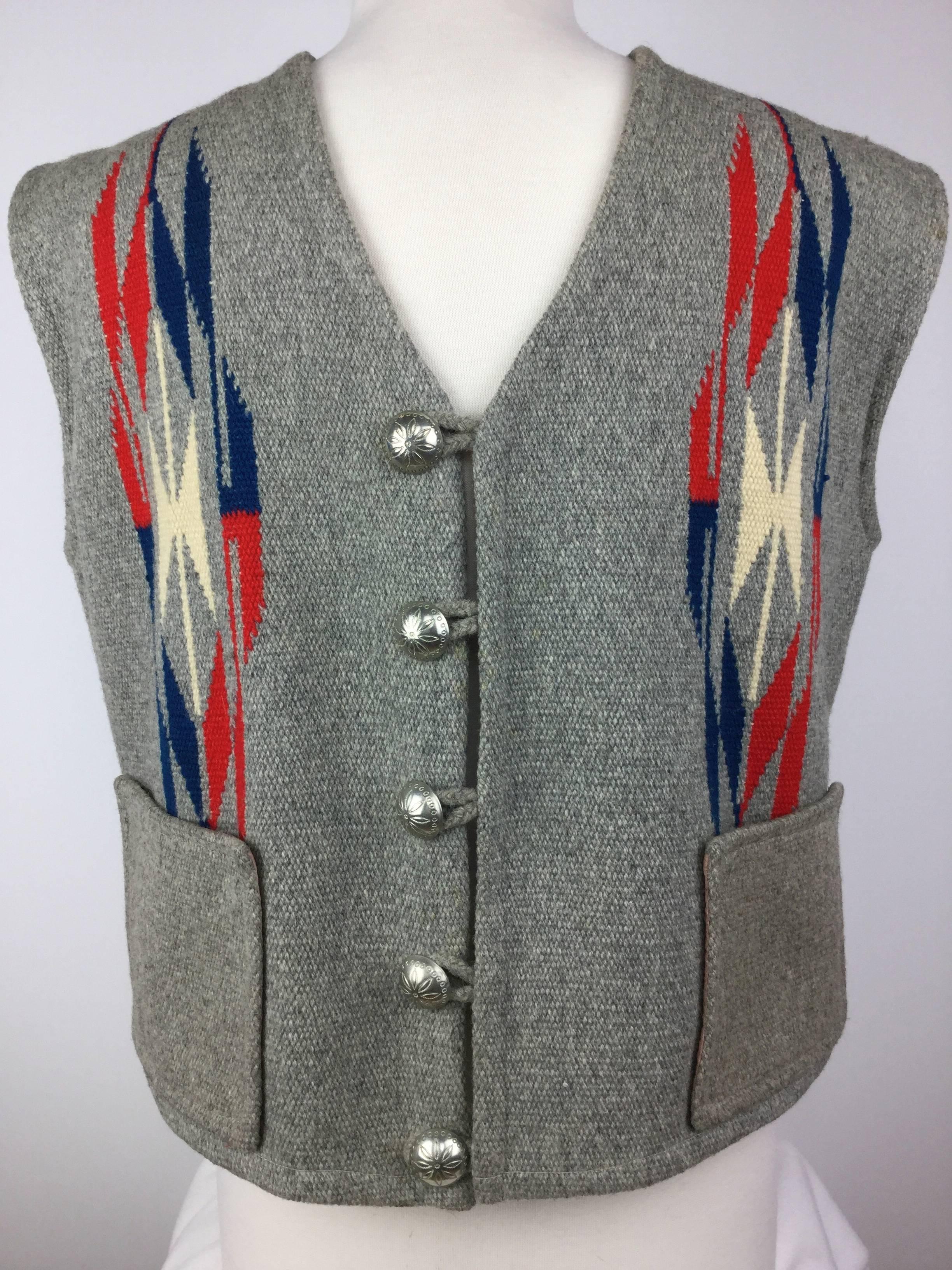 
1950's Native American style men's wool vest made from a hand woven 
Chimayo blanket.

This handsome piece has a vivid, geometric pattern repeated on both 
sides of the chest and the center of the back.

Closes with stamped Native American