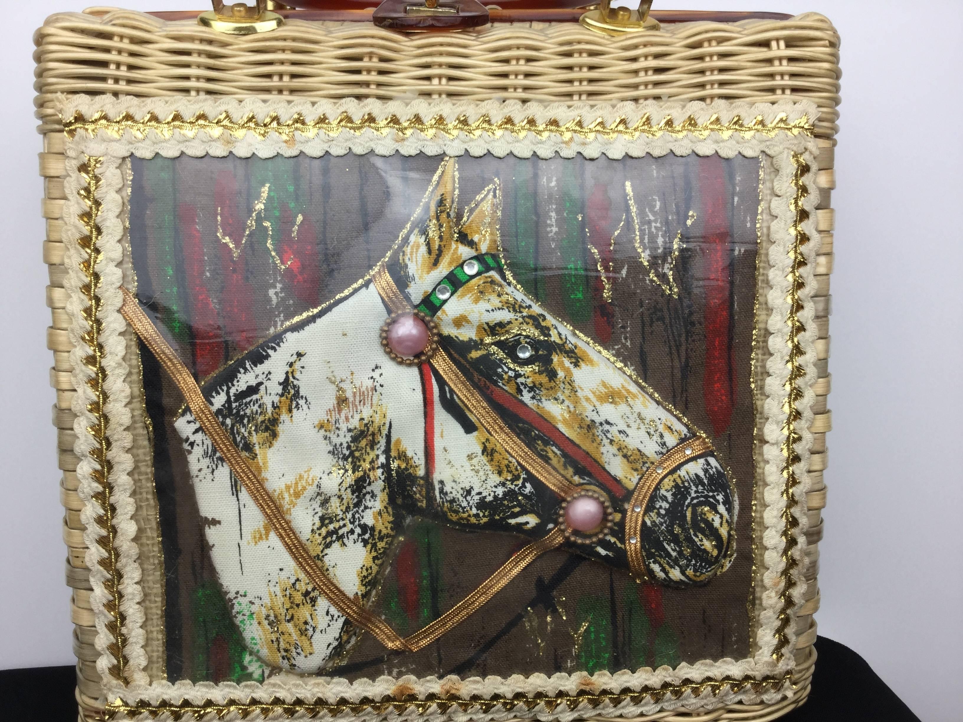 
Attractive and unusual equestrian themed vintage wicker handbag dating from the mid 1950's.

The fabric horse portrait is raised from the background, as if quilted, creating a wonderful 3-D feel.

It is decorated with a collage of pastes, pink