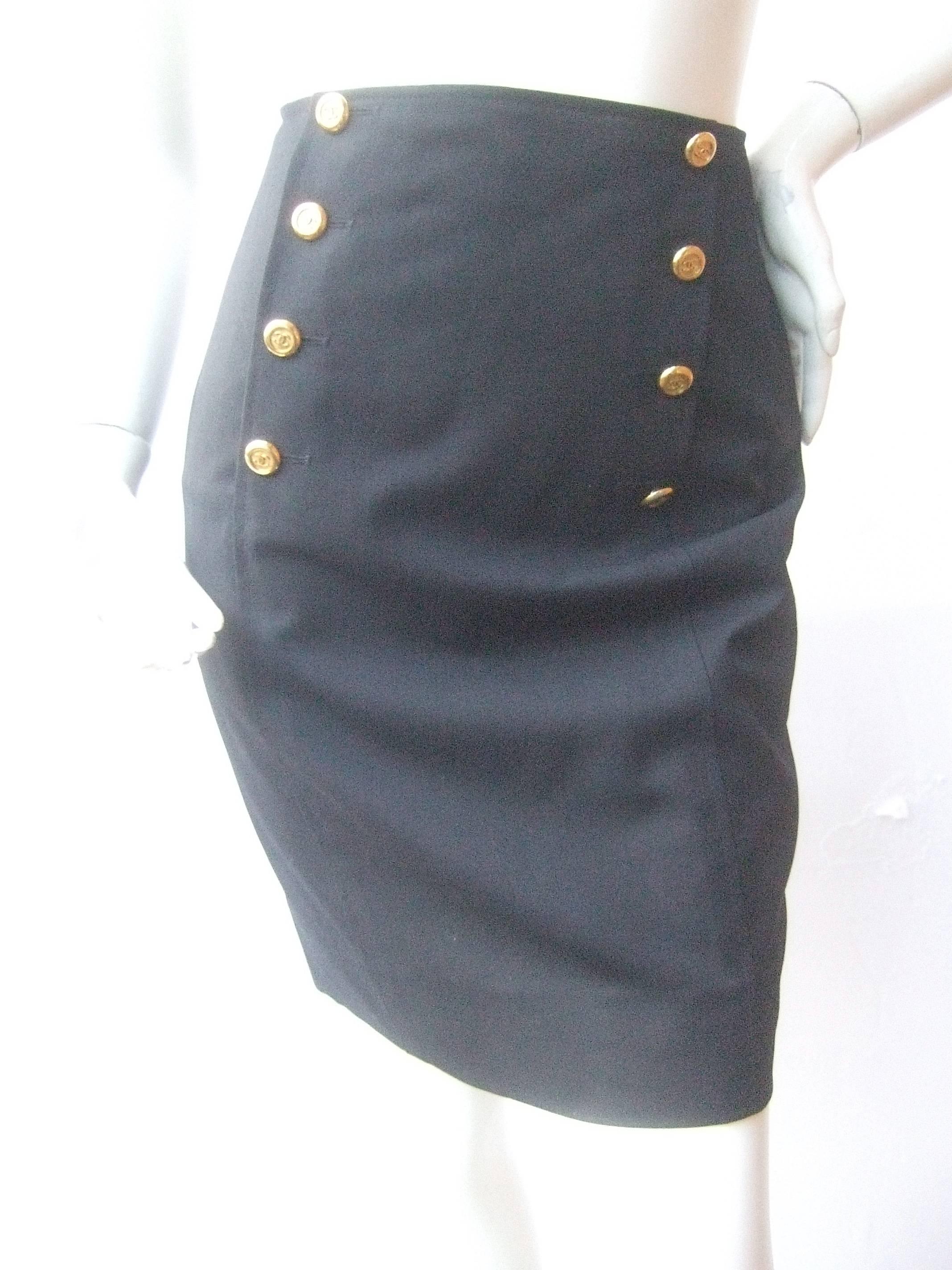 Chanel Boutique Dark blue wool pencil skirt Size 40
The classic designer light wool skirt has a nautical
influence with eight gilt metal C.C logo buttons 

The chic skirt is designed with a small kick pleat
slit on the center backside. Lined in