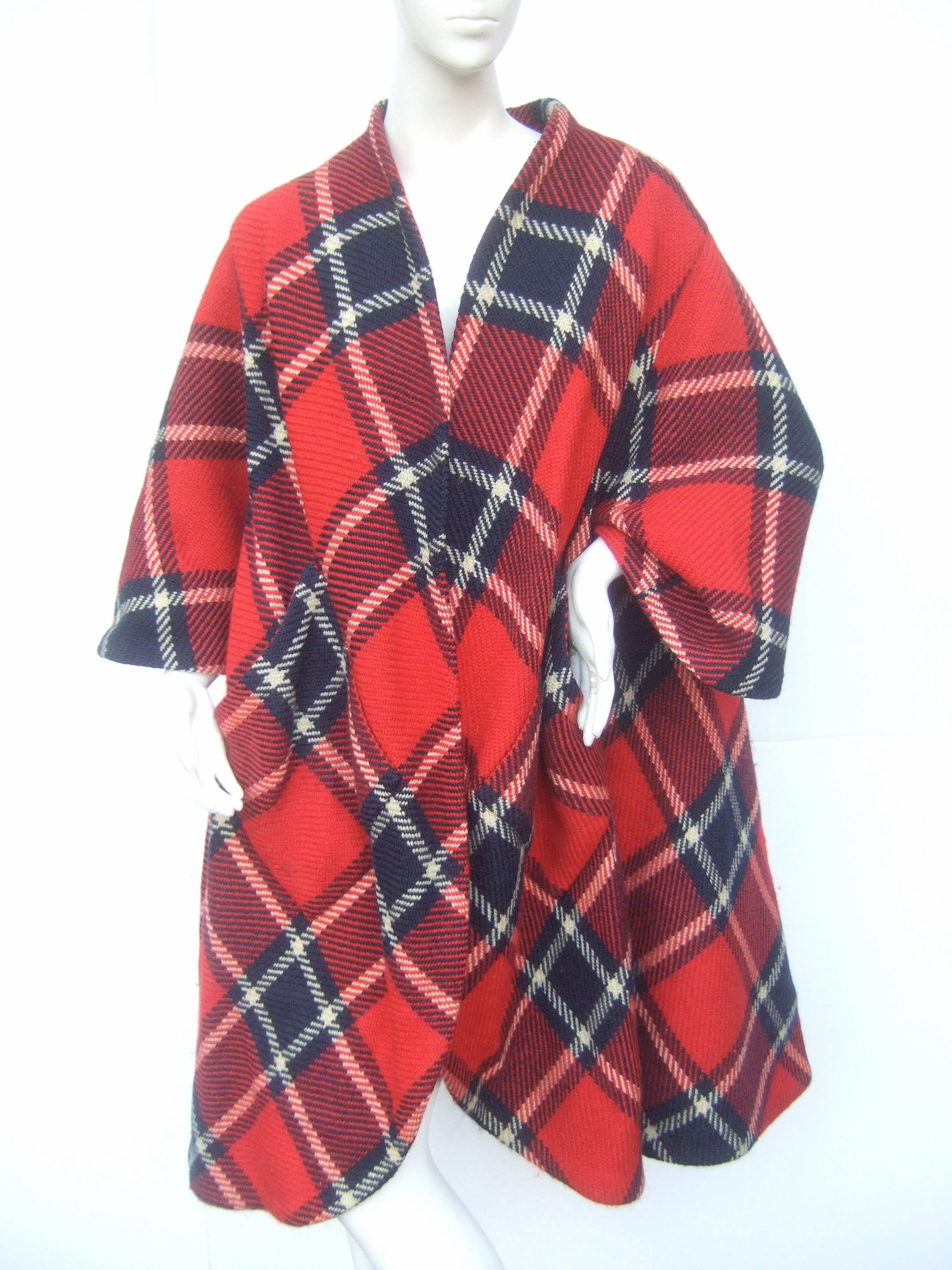 1960s Pauline Trigere Mod plaid wool swing coat 
The stylish retro light weight coat is designed
with bold tartan plaid wool fabric 

The coat is designed with bracelet length
sleeves and two wide slant patch pockets 
on the front. The loose