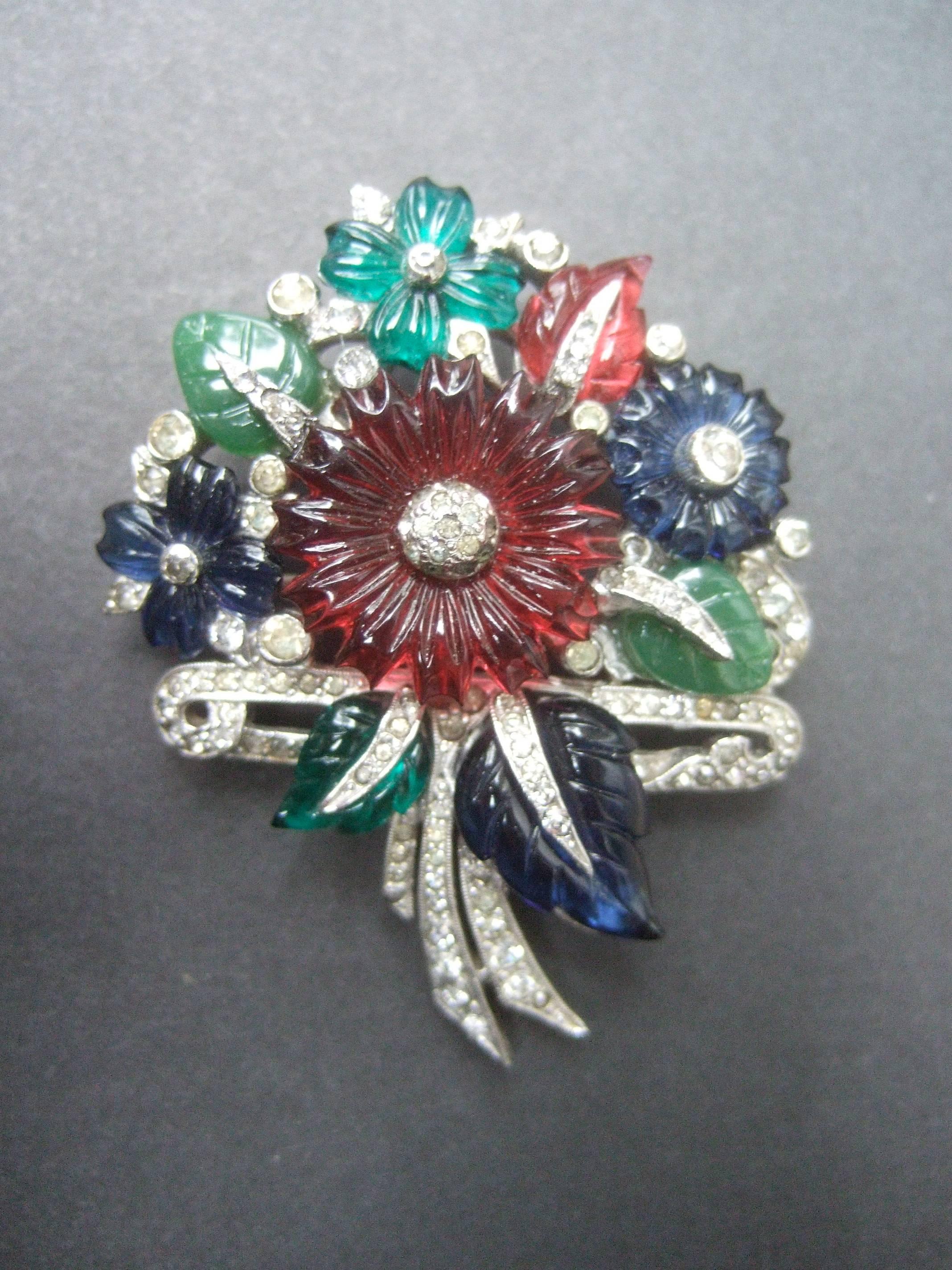 Art Deco Carved glass flower bouquet brooch c 1940
The elegant costume brooch is encrusted with 
clusters of jewel tone glass flowers and leaves

The ruby red, emerald green and sapphire blue
carved glass flowers and leaves emulate precious 