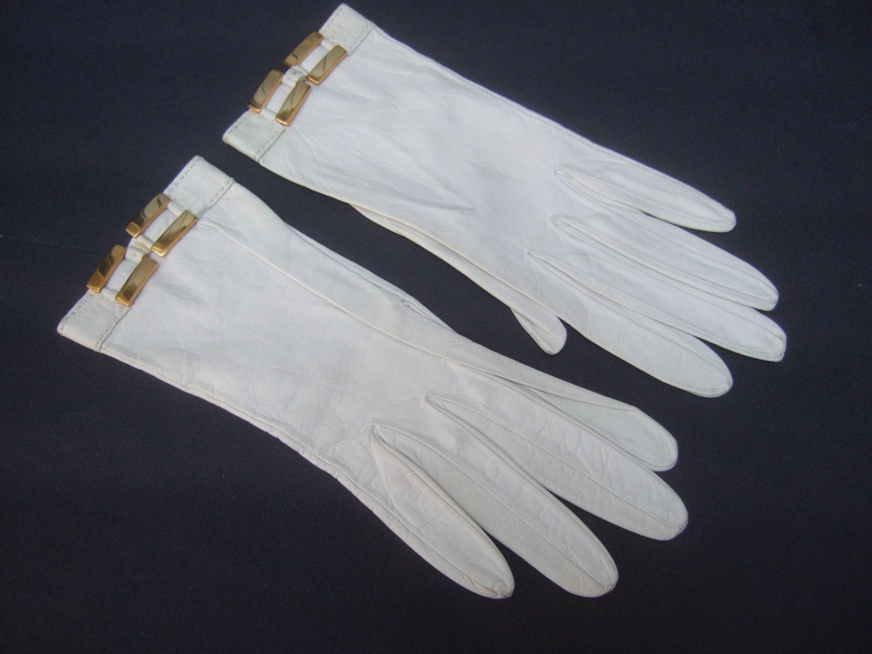 Hermes Paris White kidskin leather gloves ca 1970
The elegant retro gloves are designed with supple
white leather adorned with gilt metal buckles

The classic white leather glove makes a chic 
timeless accessory

Stamped Hermes Paris