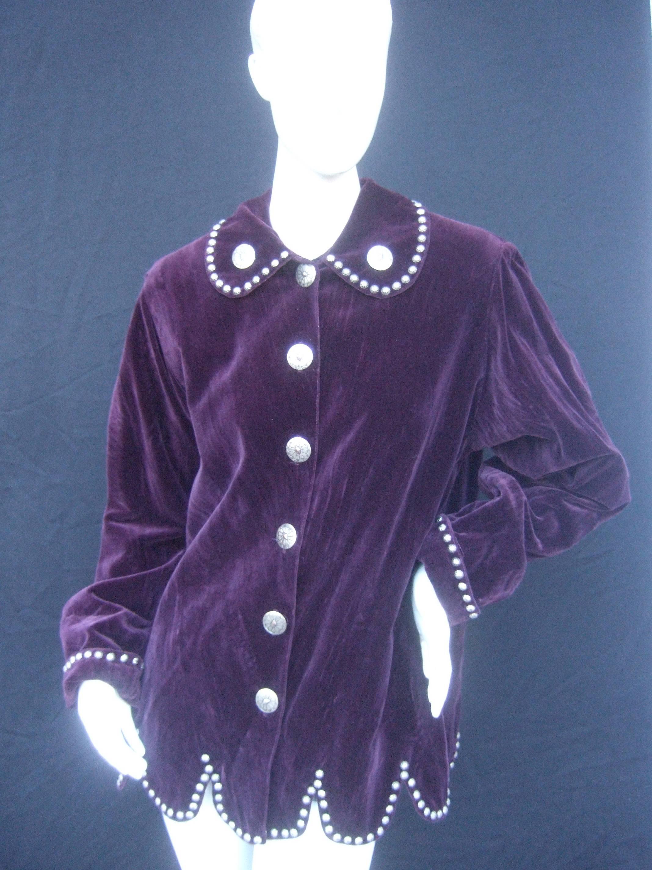 Unique plum cotton velvet silver metal grommet jacket
The amethyst color cotton velvet jacket is embellished
with silver metal grommets that frame the collar,
circle the folded cuffs and accent the scalloped 
hemline

The collar lapels and the