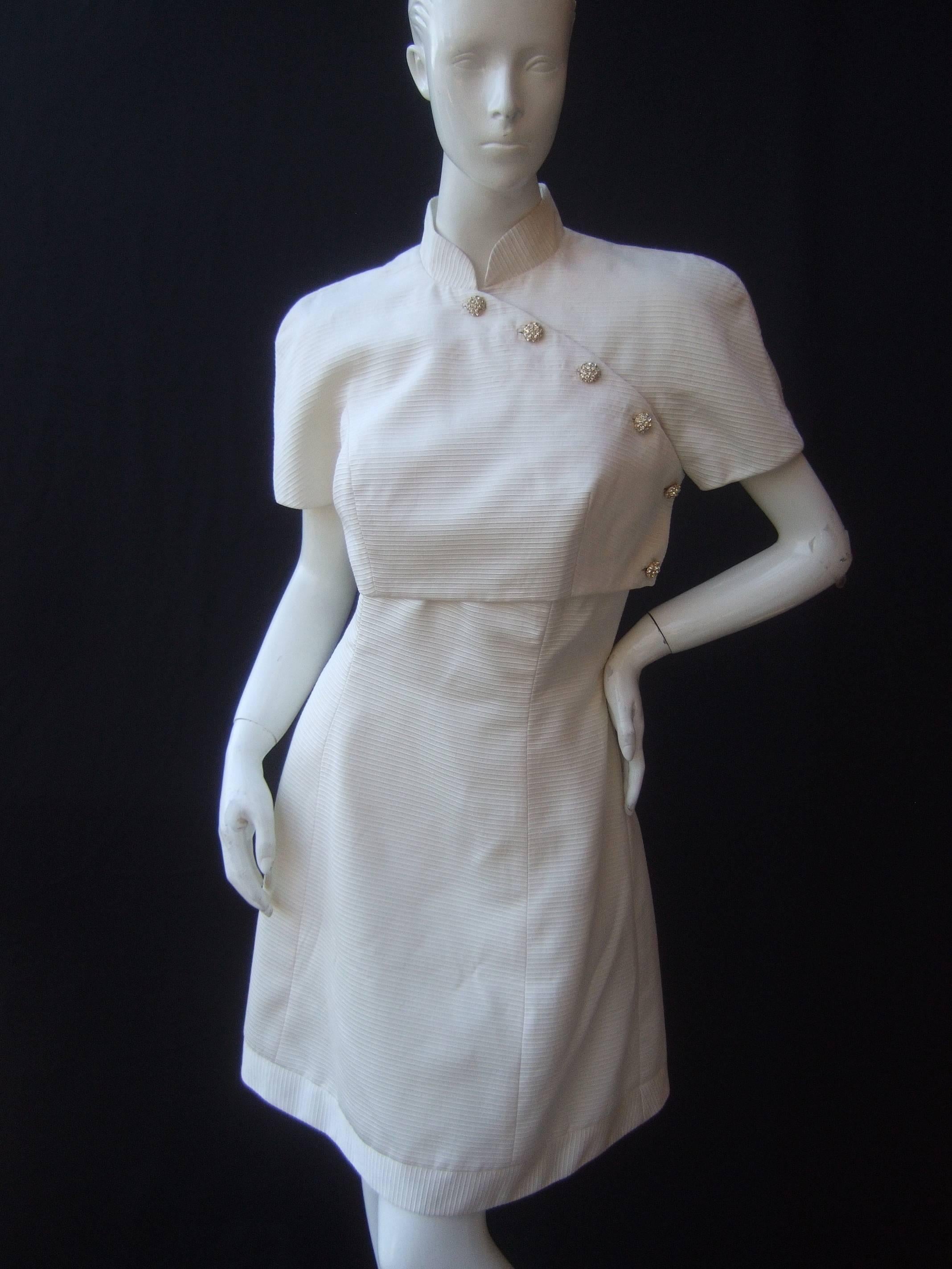 Crisp ivory jacket and dress ensemble by Fabian Molina
The stylish dress is paired with a short cropped 
sleeveless jacket embellished with diamante 
crystal buttons

The strapless cocktail dress is designed
with a heart shaped bodice