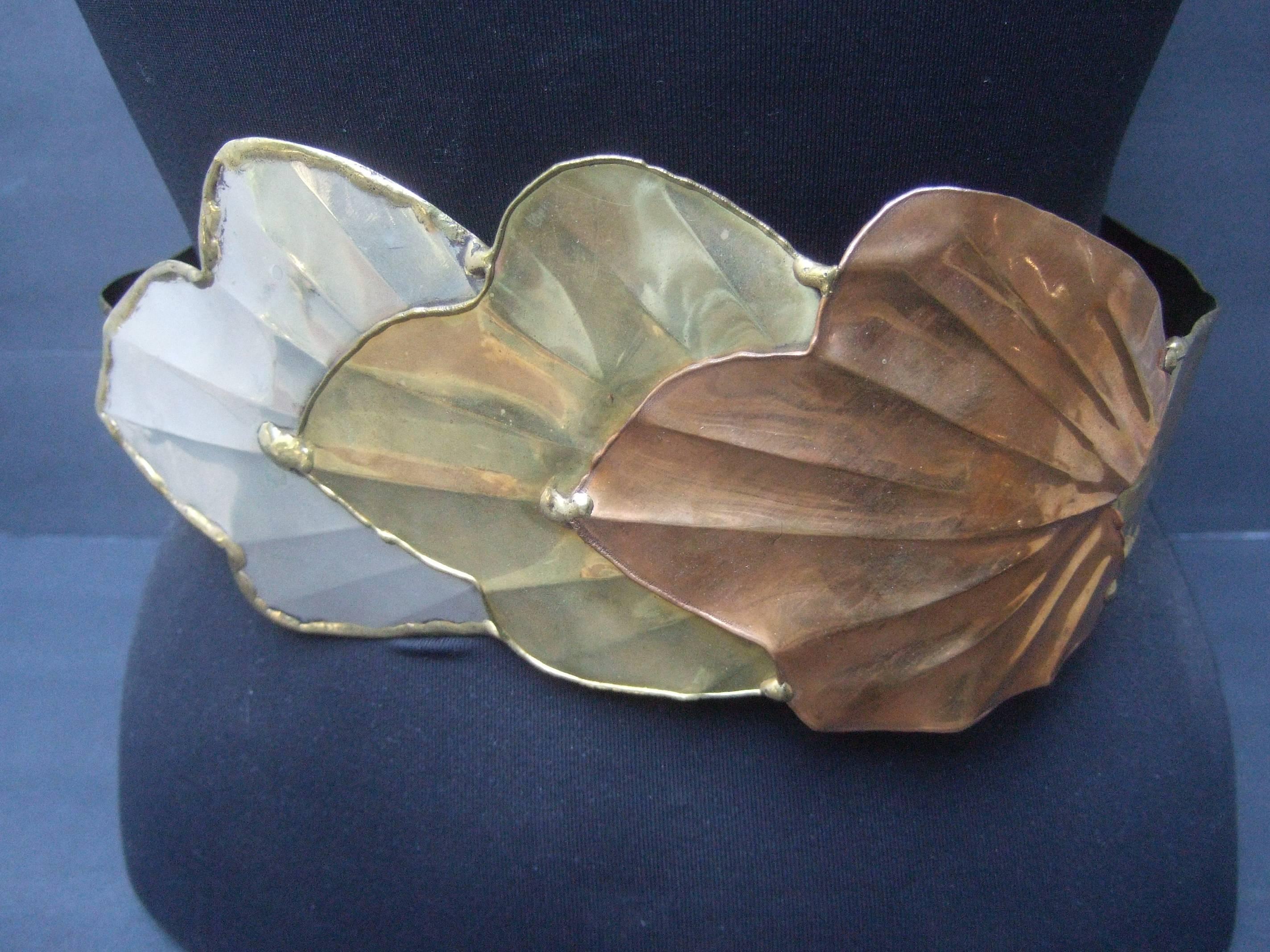 Massive avant-garde mixed metal leaf belt c 1980s
The artisan belt is designed with a trio
of huge scale mixed metal leaves 

The large scale leaves range from silver metal,
brass tone metal combined with a copper
metal leaf

The trio of