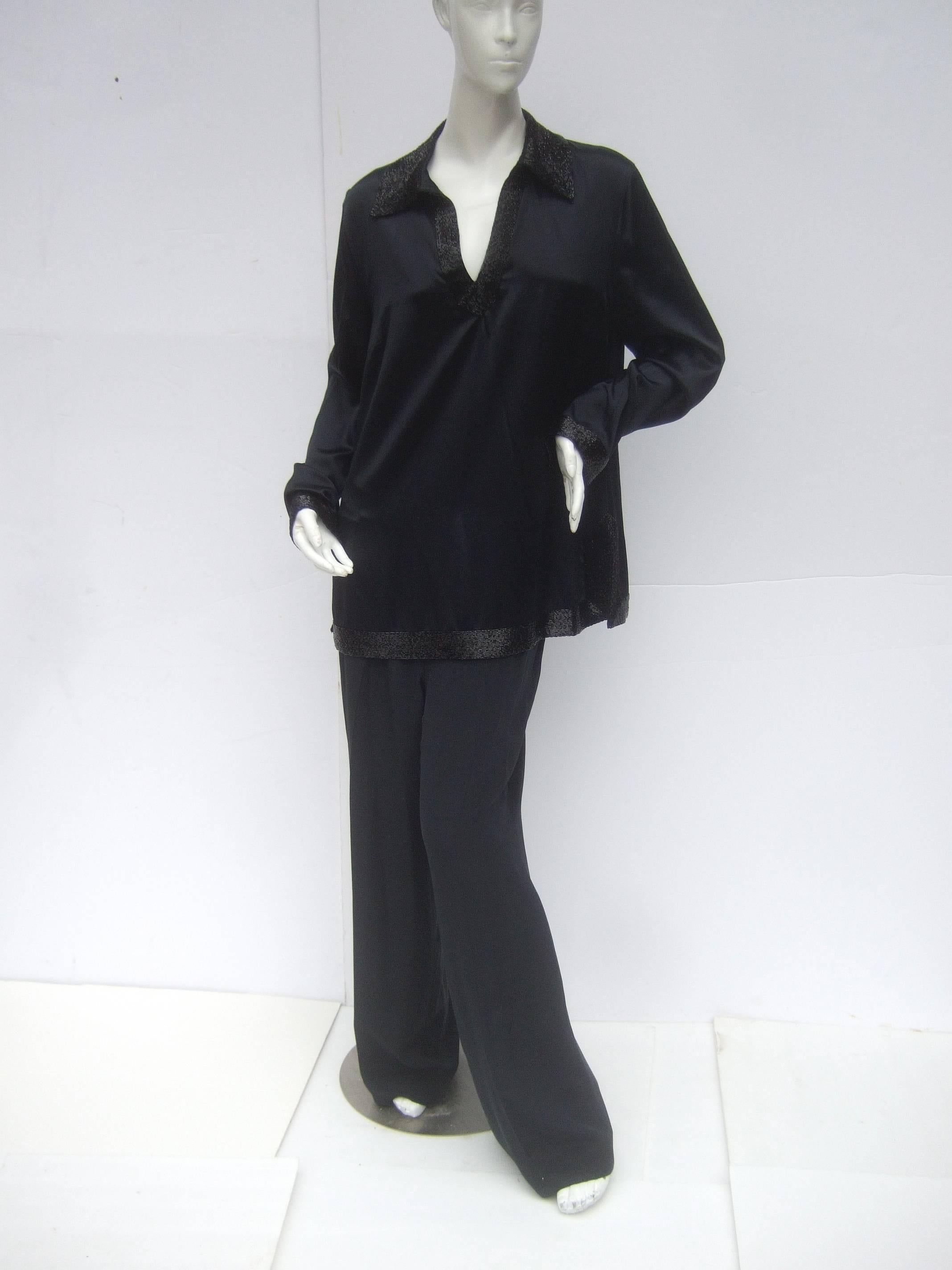 Jaeger Elegant black silk charmeuse tunic / trouser ensemble
The stylish tunic is embellished with restrained black 
glass bugle beading around the collar, cuffs and hemline
The tunic blouse is designed with a v-slit on the front;
the sides have