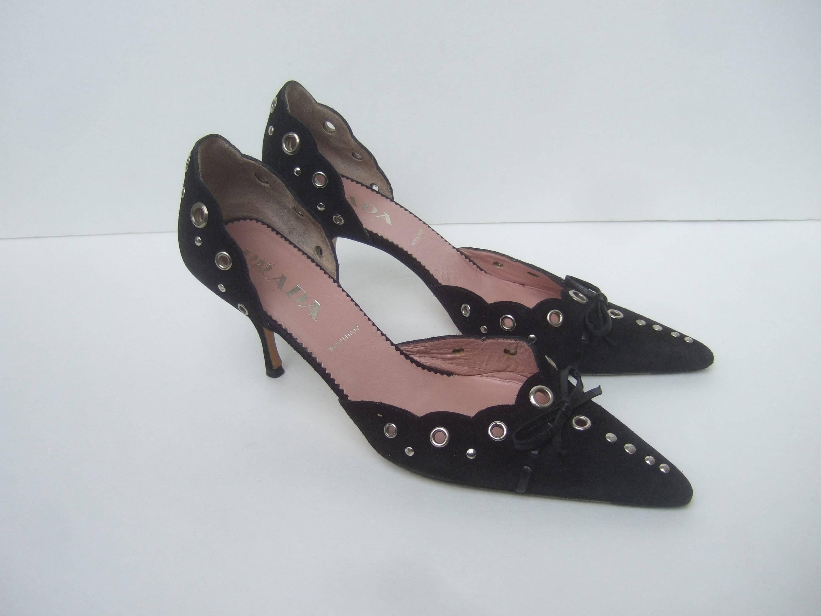 Prada Black suede grommet pumps Size 38
The stylish Italian heels are covered with
plush black suede. Accented with chrome
metal grommets

The pointed toe heels are embellished with
black leather bows on the front. The grommet
detail extends