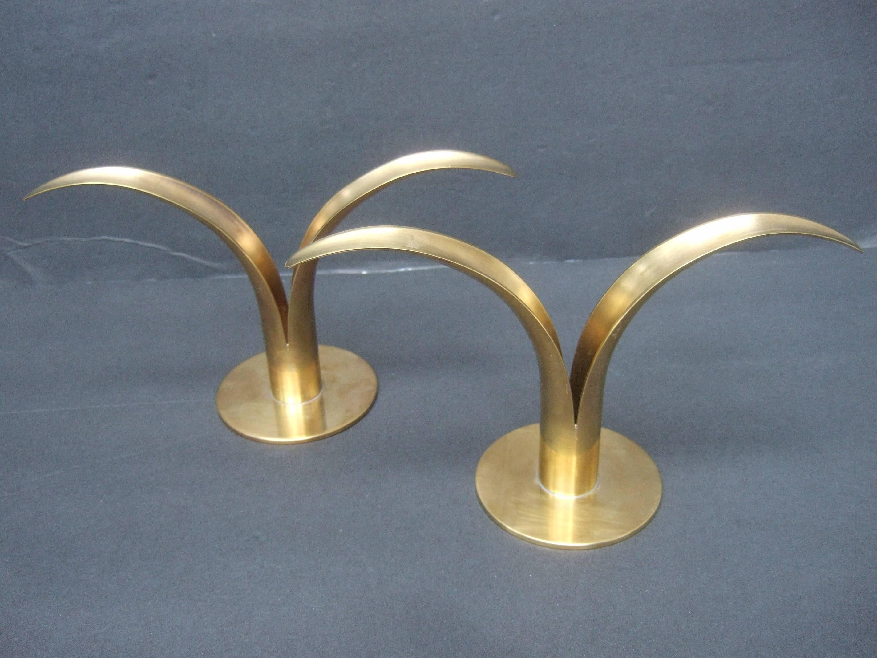 Sleek pair of Danish modern fluted brass metal candle holders
The stylized brass metal candle holders have a severe
minimal mid century design 

Each of the diminutive candle holder is designed with curved 
bands that emulate organic foliage.