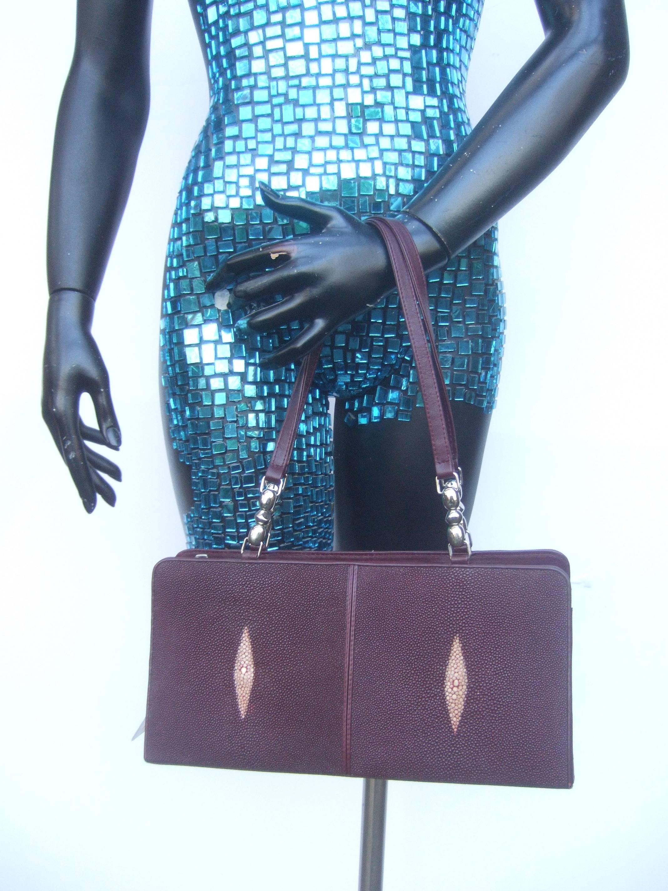 Exotic genuine stringray burgundy handbag 
The unique handbag is covered with stringray 
skin. Carried with twin burgundy leather handles

The handle straps are accented with sleek chrome
metal hardware. The interior is lined in golden