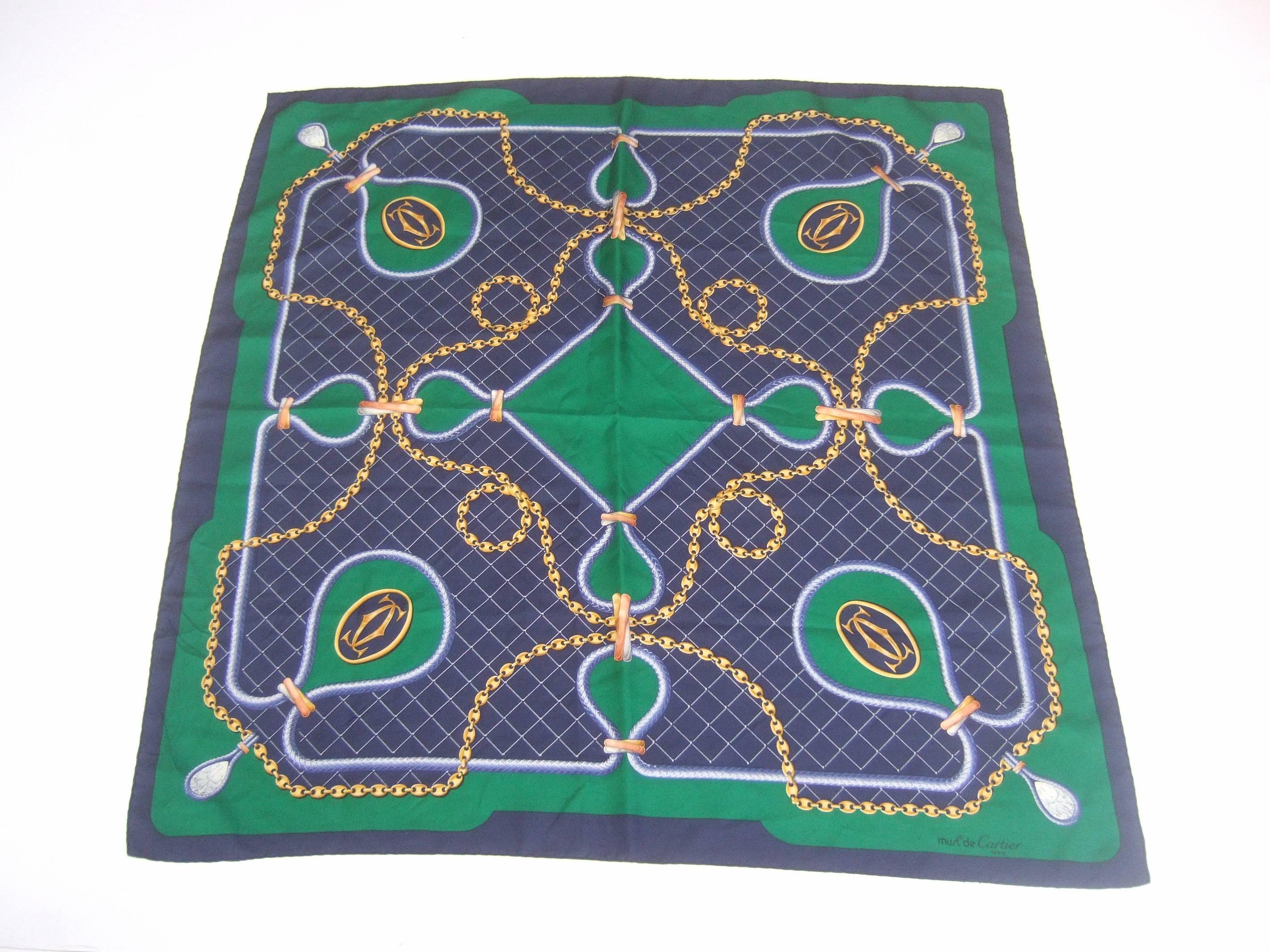 Cartier Paris Silk sports racquet theme hand rolled scarf 
The stylish silk scarf is illustrated with a net design
in the center accented with sinuous gilt style chains

The racquets are adorned with Cartier's interlocked
C.C. initials. The