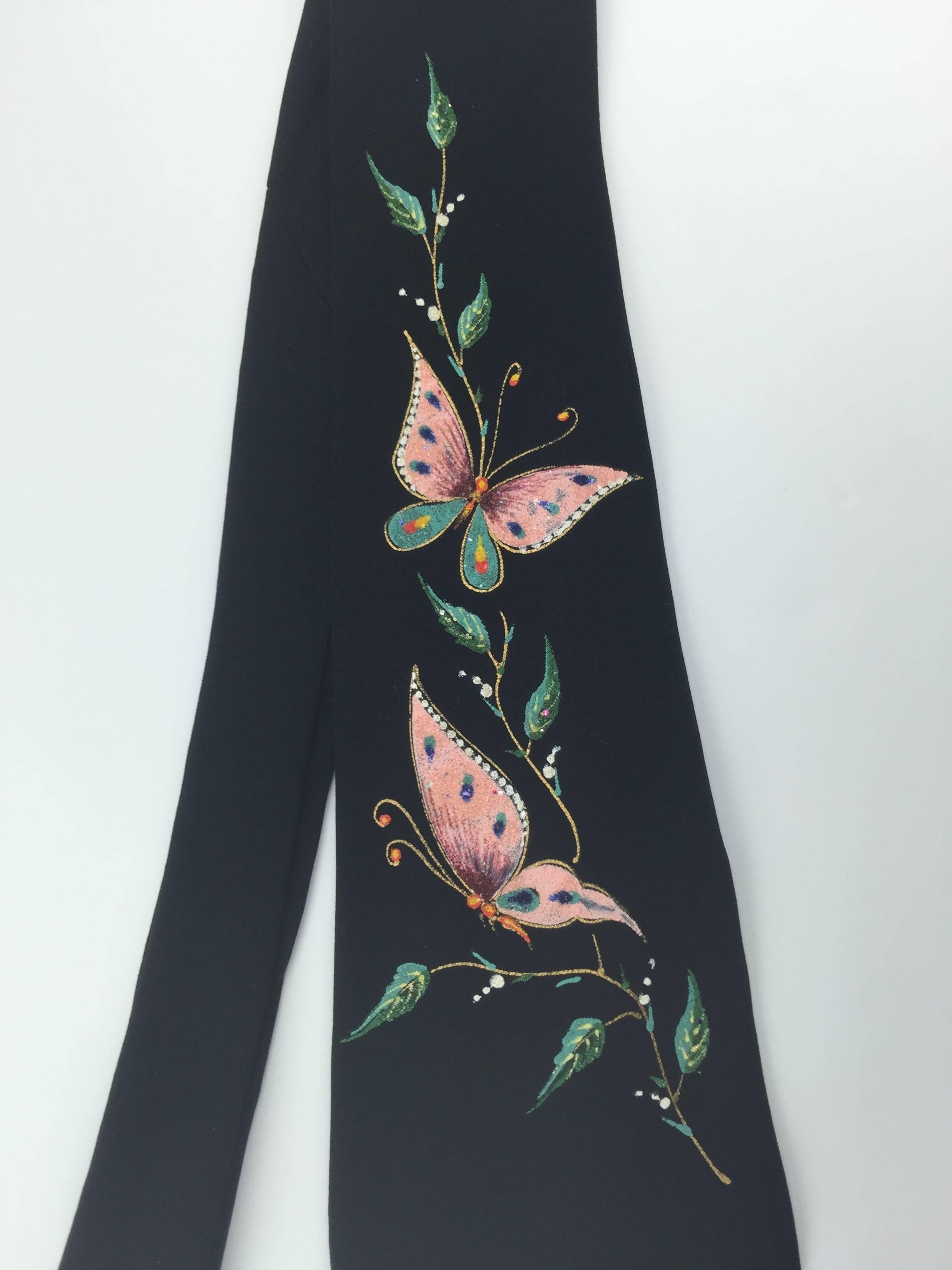This is a stunning 1950's tie in mint condition. 

Delicate hand painted butterfies are enlivened with tiny but subtle glitter sparkles that make the design shimmer with an understated glamour.

They hover on a leafy vine.

Vivid palette of