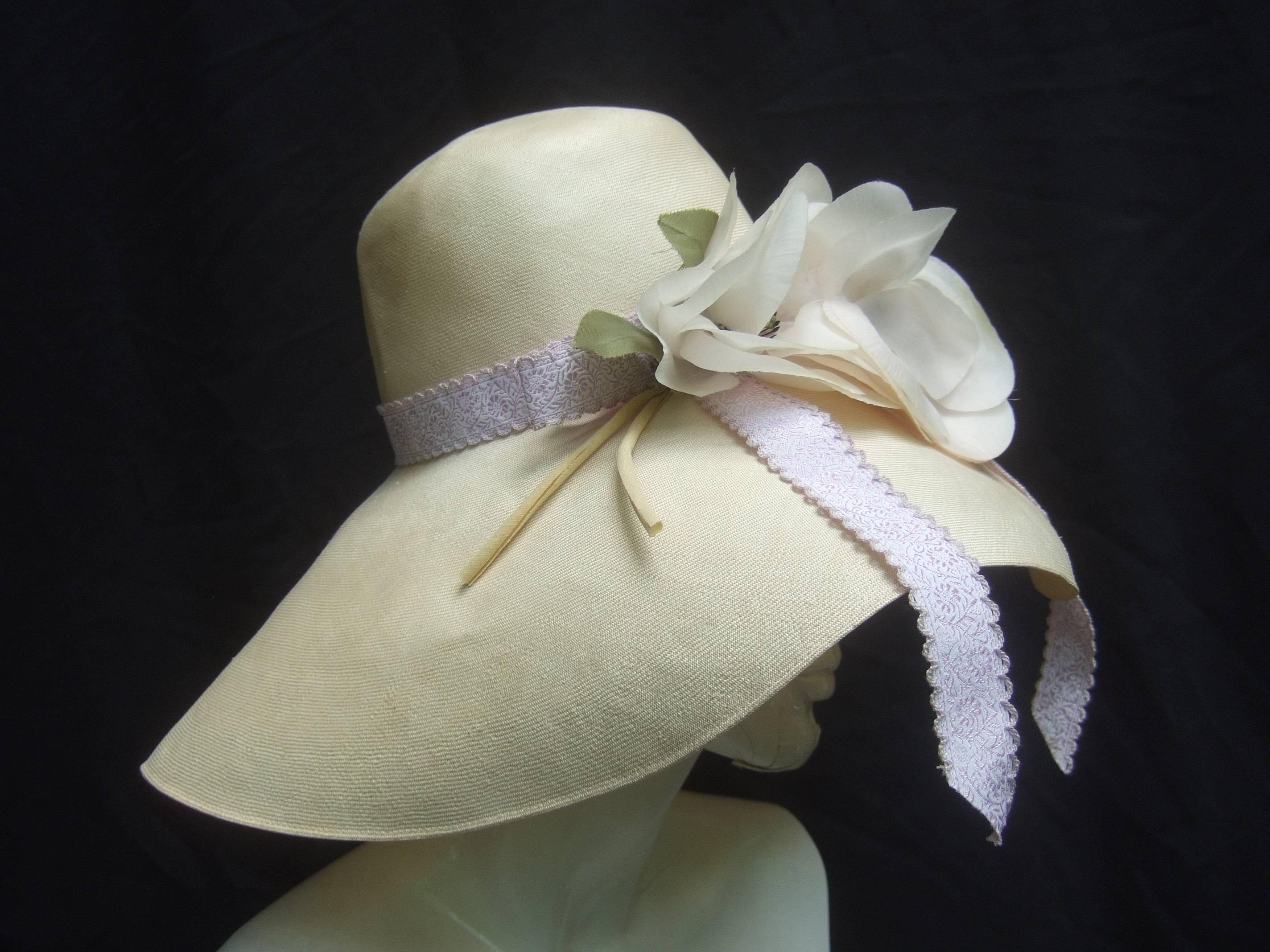 Saks Fifth Avenue Romantic raffia hat by Adolfo
The light breezy raffia hat is adorned with 
a pair of lush white camellia flowers
Accented with a billowy lavender ribbon   

Makes a very dramatic accessory perfect
for and summer and resort