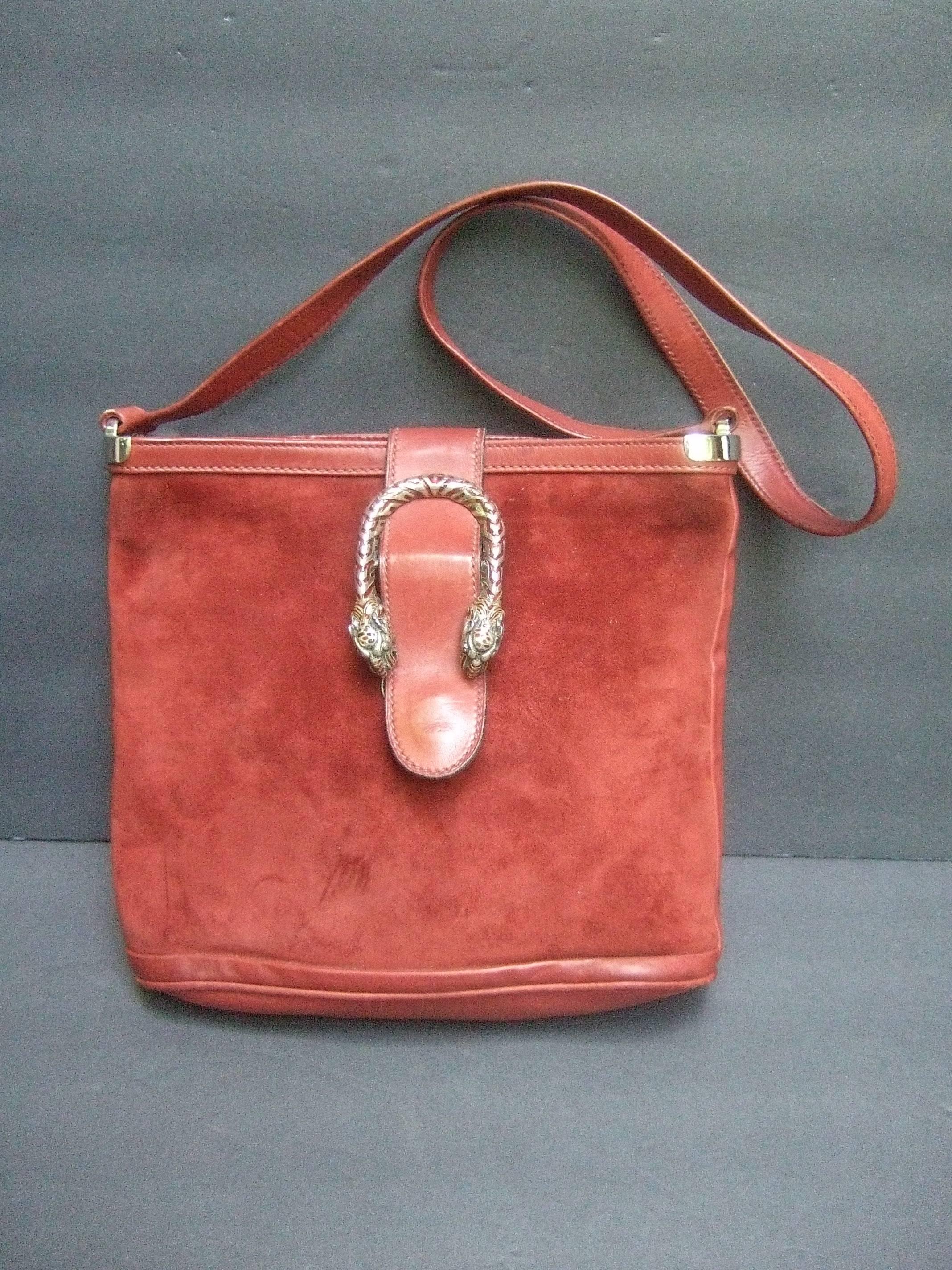 Gucci Italy extremely rare sterling silver tiger clasp handbag
The luxurious designer saddle style shoulder bag 
is adorned with an ornate sterling silver enamel
clasp with a pair of tiger head's

The plush burgundy suede covering is