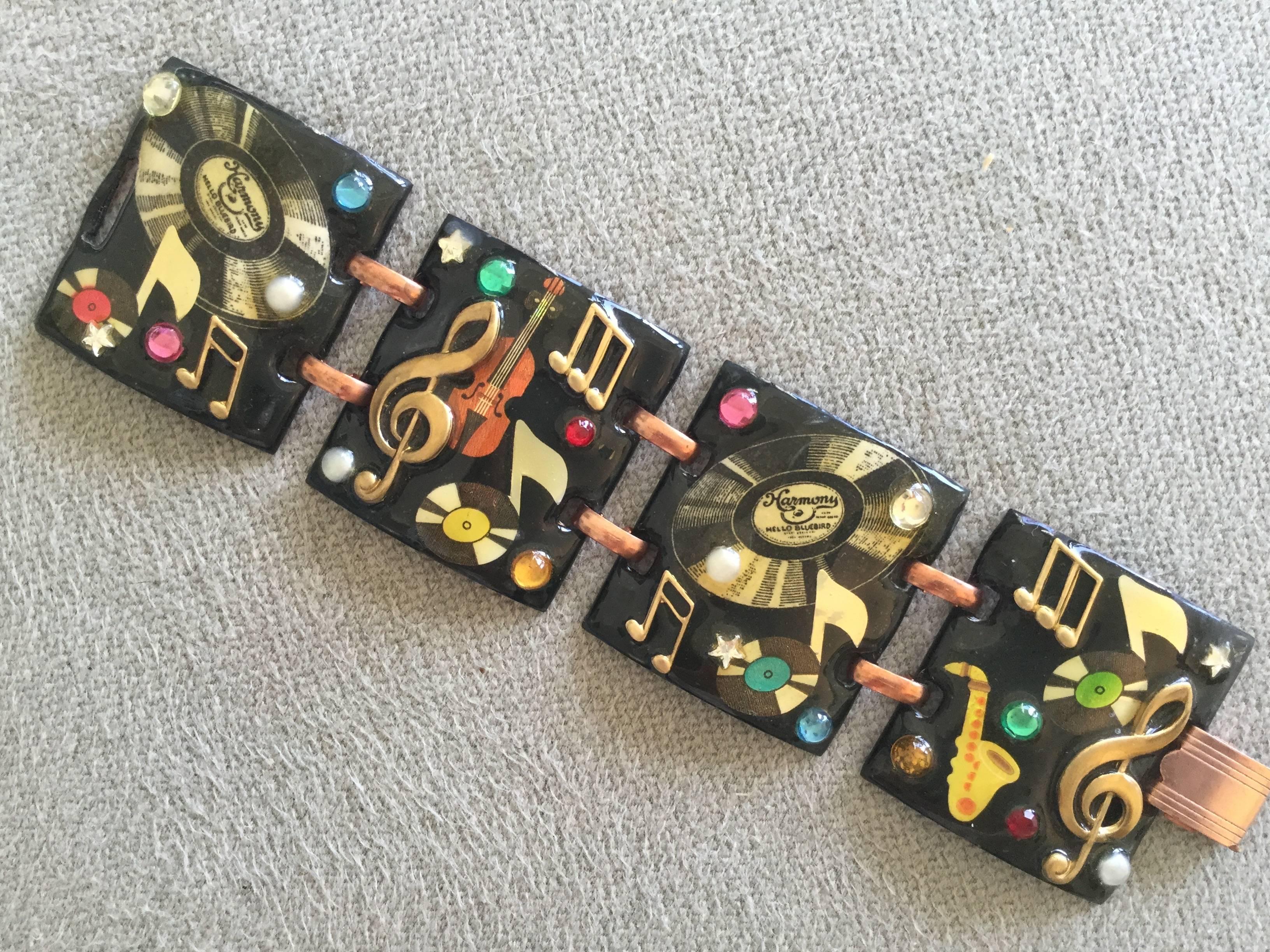 This is such a fun piece from the late 1950's.  Enamel on copper bracelet
depicting instruments, musical notes, and record albums. Further enlivened with faux pastes and pearls.  Most probably made in a mid-century California artisan's metalwork
