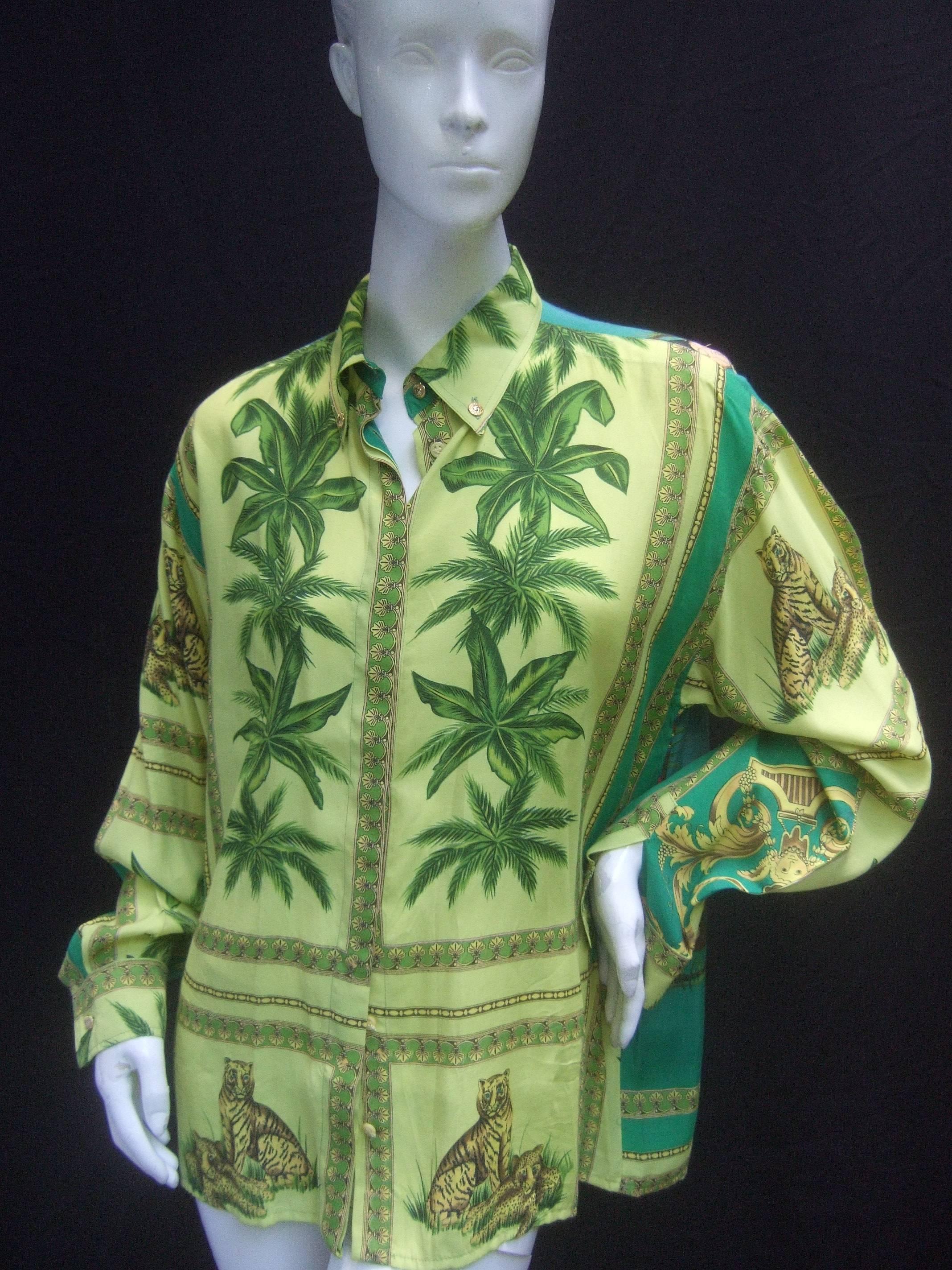 Versace Tropical jungle print tarzan blouse ca 1990s
The exotic print blouse is illustrated with lions
and leopards surrounded by lush tropical foliage 

Swinging thru the palm trees is a loin cloth tarzan
figure. He is accompanied by a female