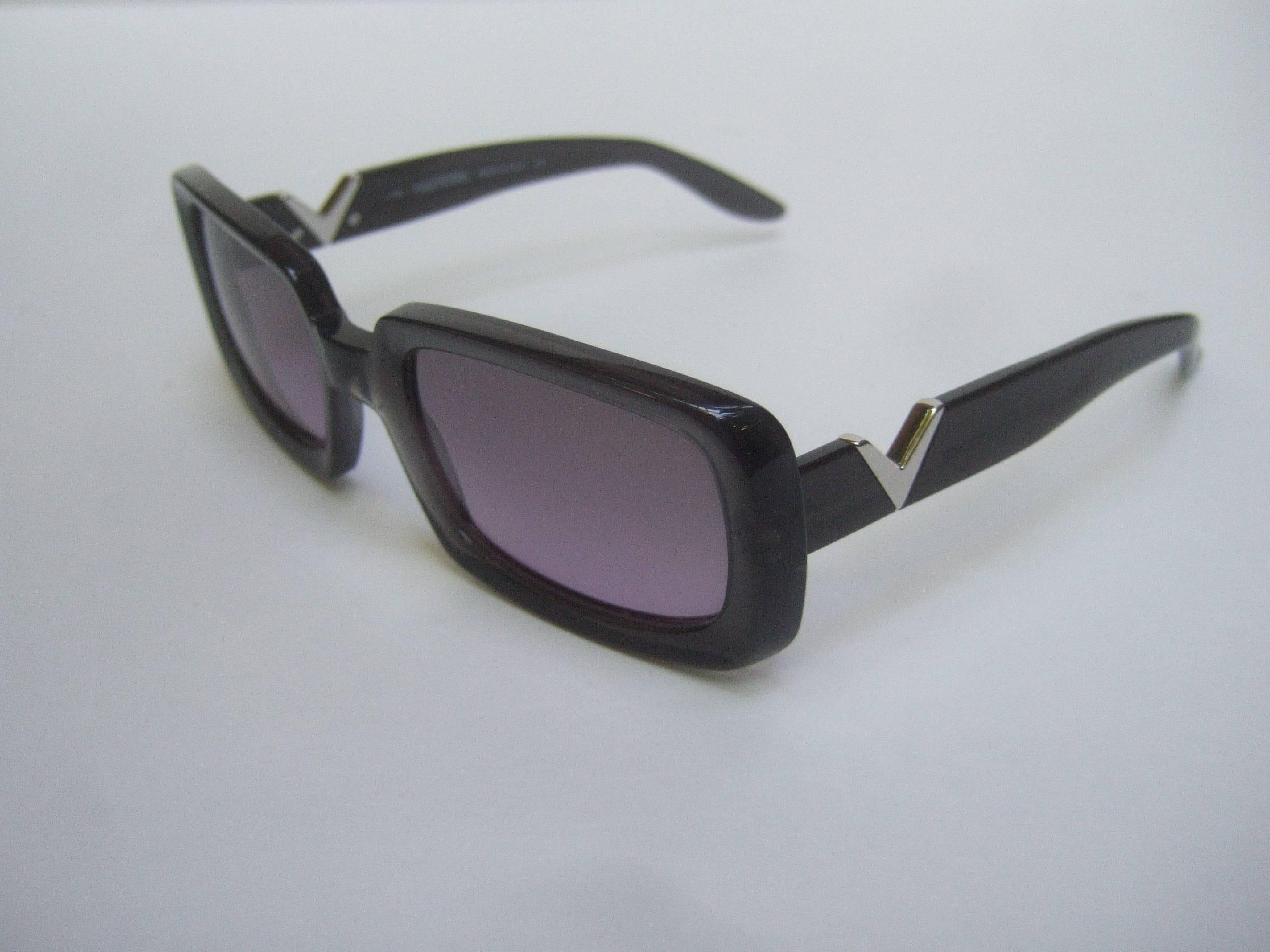 Valentino Sleek ebony lavender lens sunglasses
The stylish designer sunglasses are constructed 
with shiny black plastic frames  

Designed with lavender purple plastic lenses 
The sides are adorned with sleek chrome metal 
V initials

The